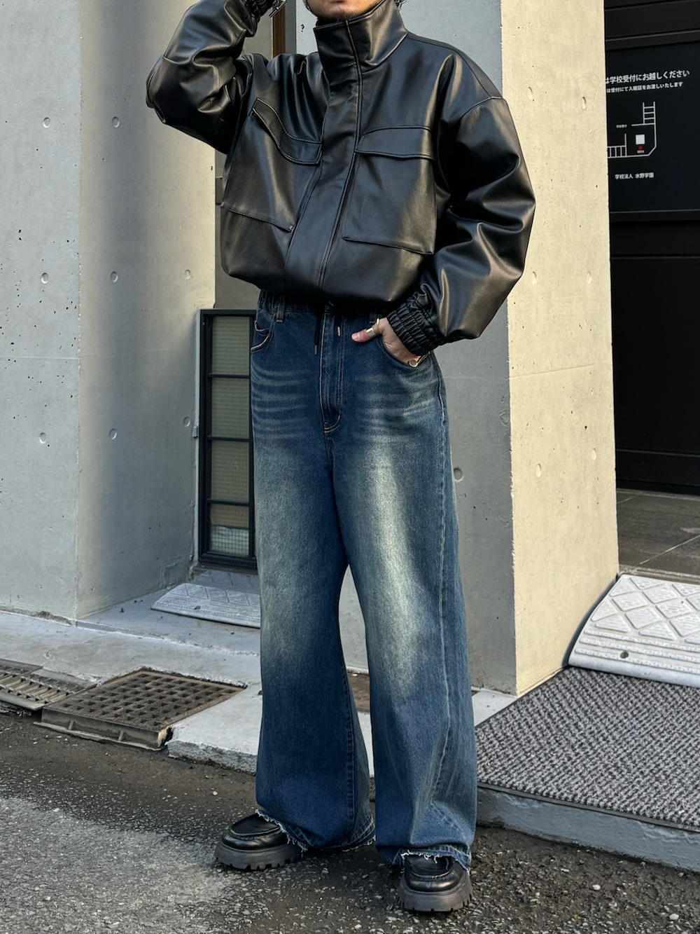 ブラック系のブルゾン、ブルー系のデニムパンツ、ブラック系のブーツを着用したメンズの冬コーディネートの3枚目の写真