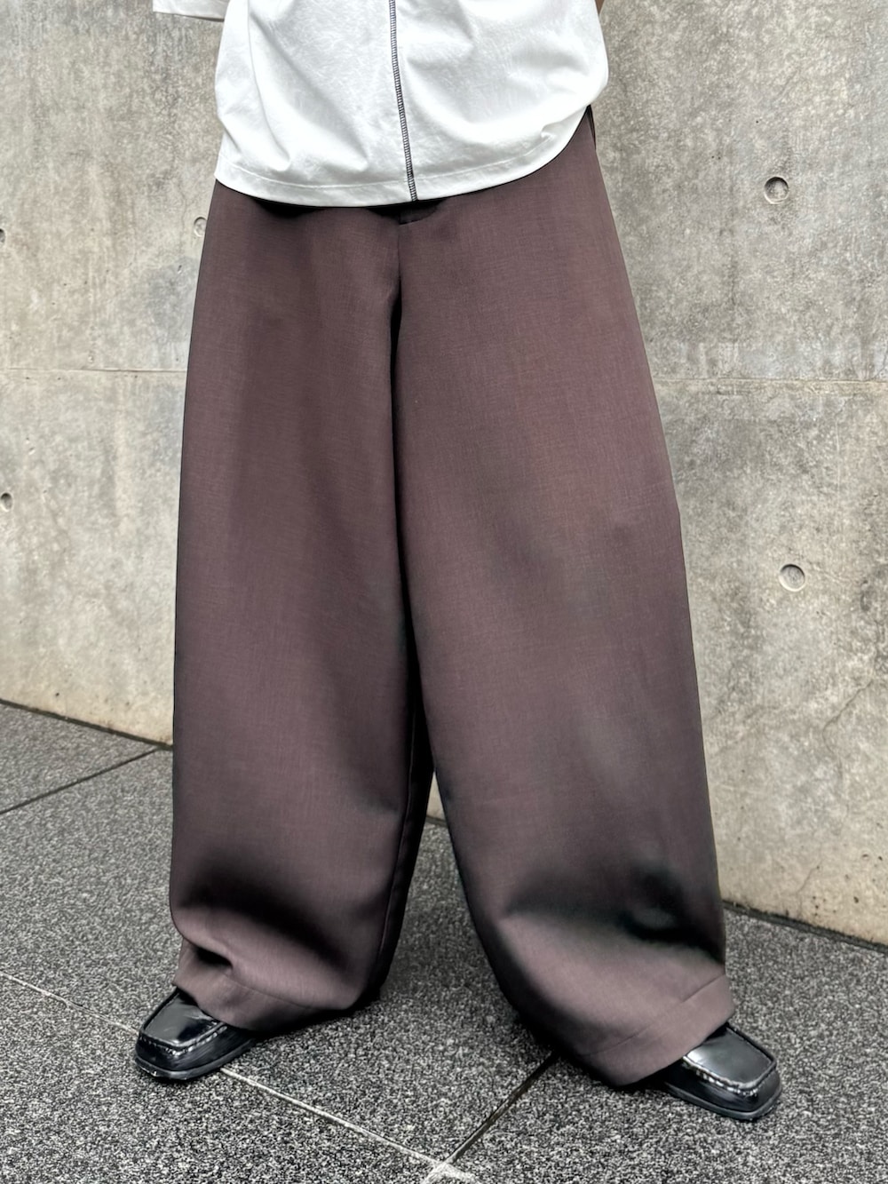 ホワイト系のTシャツ/カットソー、ブラウン系のスラックスを着用したメンズの夏コーディネートの4枚目の写真