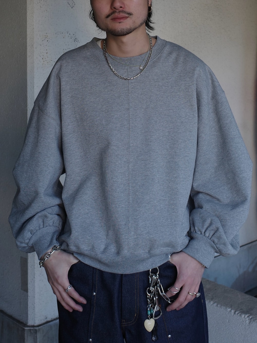 グレー系のスウェット、ブルー系のデニムパンツを着用したメンズの春コーディネートの6枚目の写真