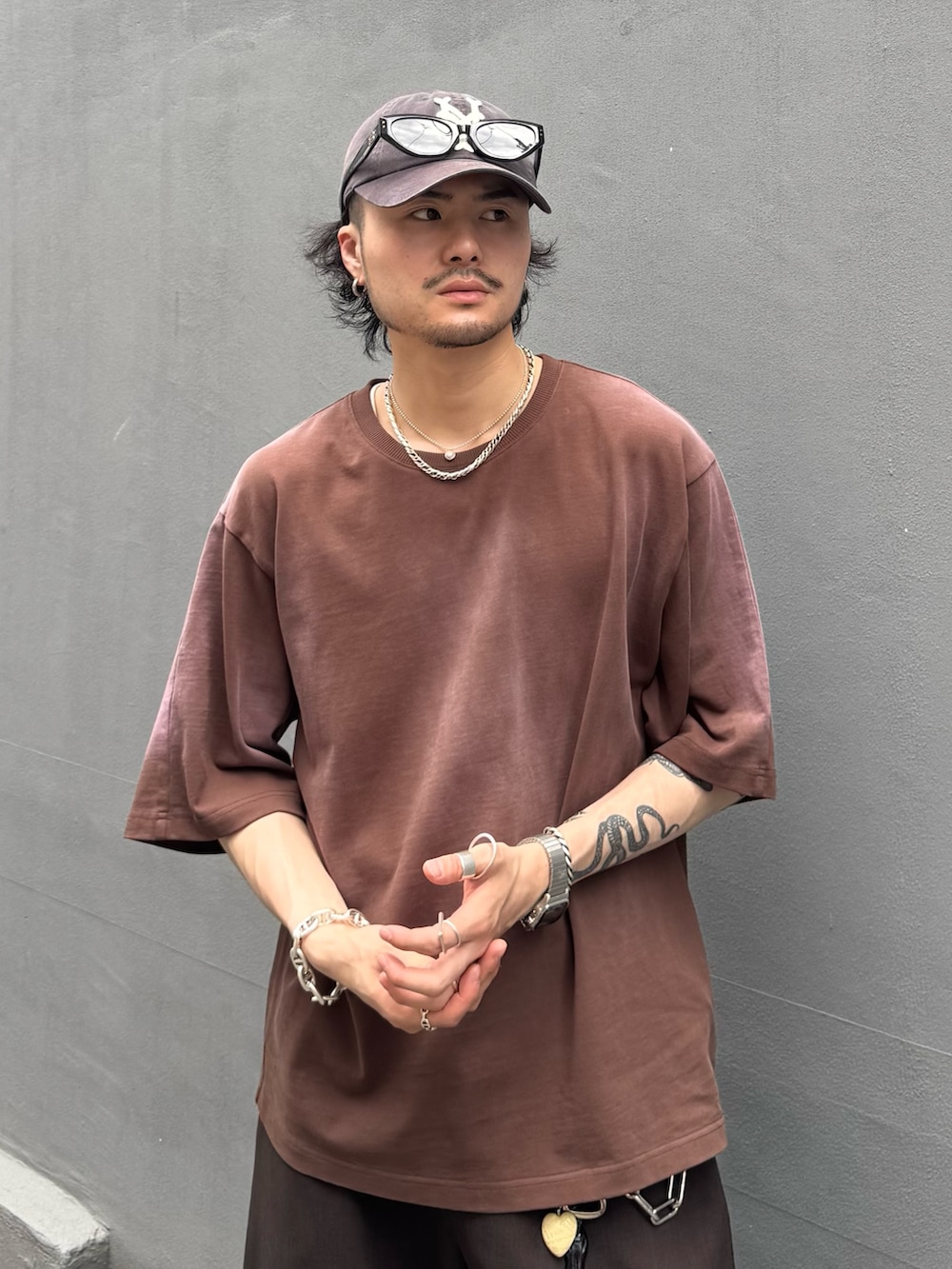 グレー系のスラックス、ブラウン系のTシャツ/カットソーを着用したメンズの夏コーディネートの4枚目の写真