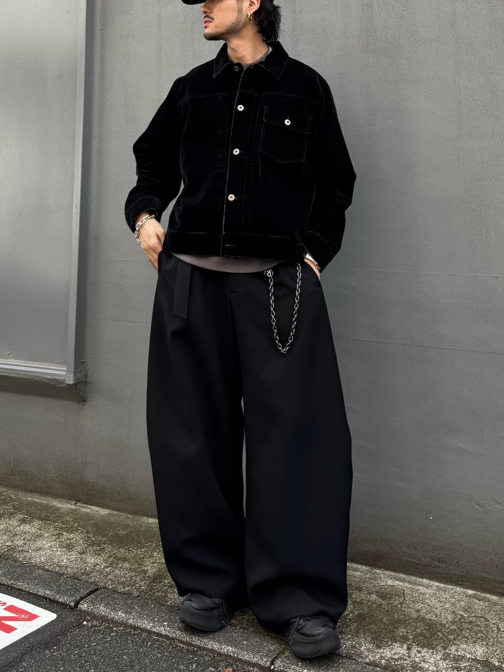 ブラック系のデニムジャケット、ブラック系のスラックス、ブラック系のウォレットチェーンを着用したメンズの春コーディネートの5枚目の写真