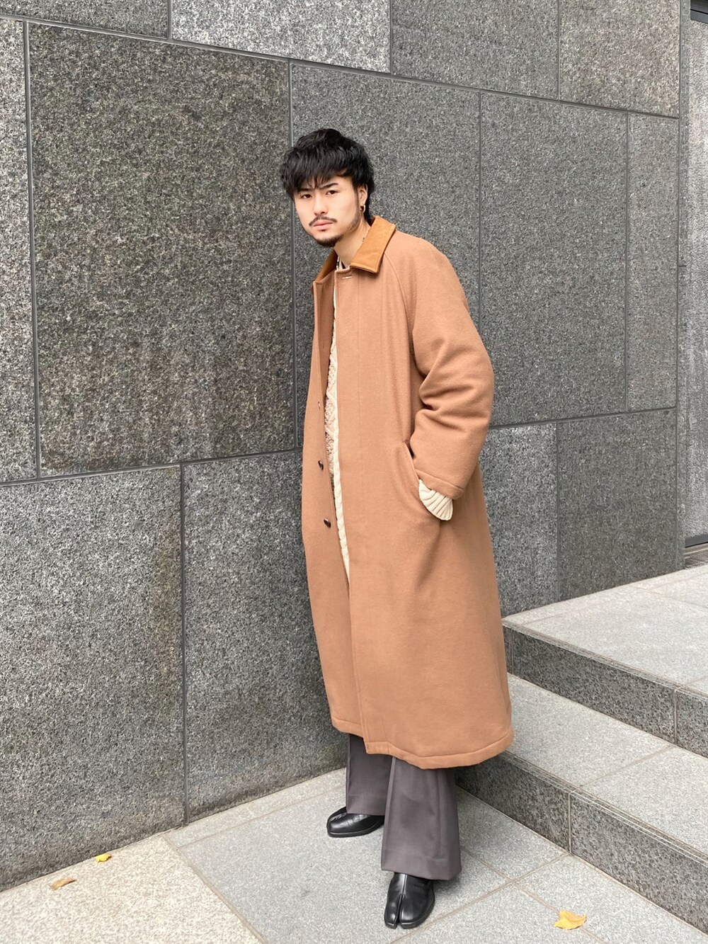 イエロー系のその他アウター、ホワイト系のニット/セーター、グレー系のスラックスを着用したメンズの冬コーディネートの3枚目の写真