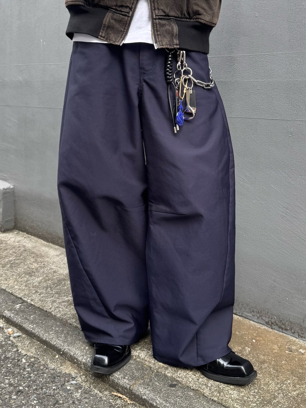 ブラウン系のデニムジャケット、ブルー系のスラックス、ブルー系のキャップを着用したメンズの秋コーディネートの6枚目の写真