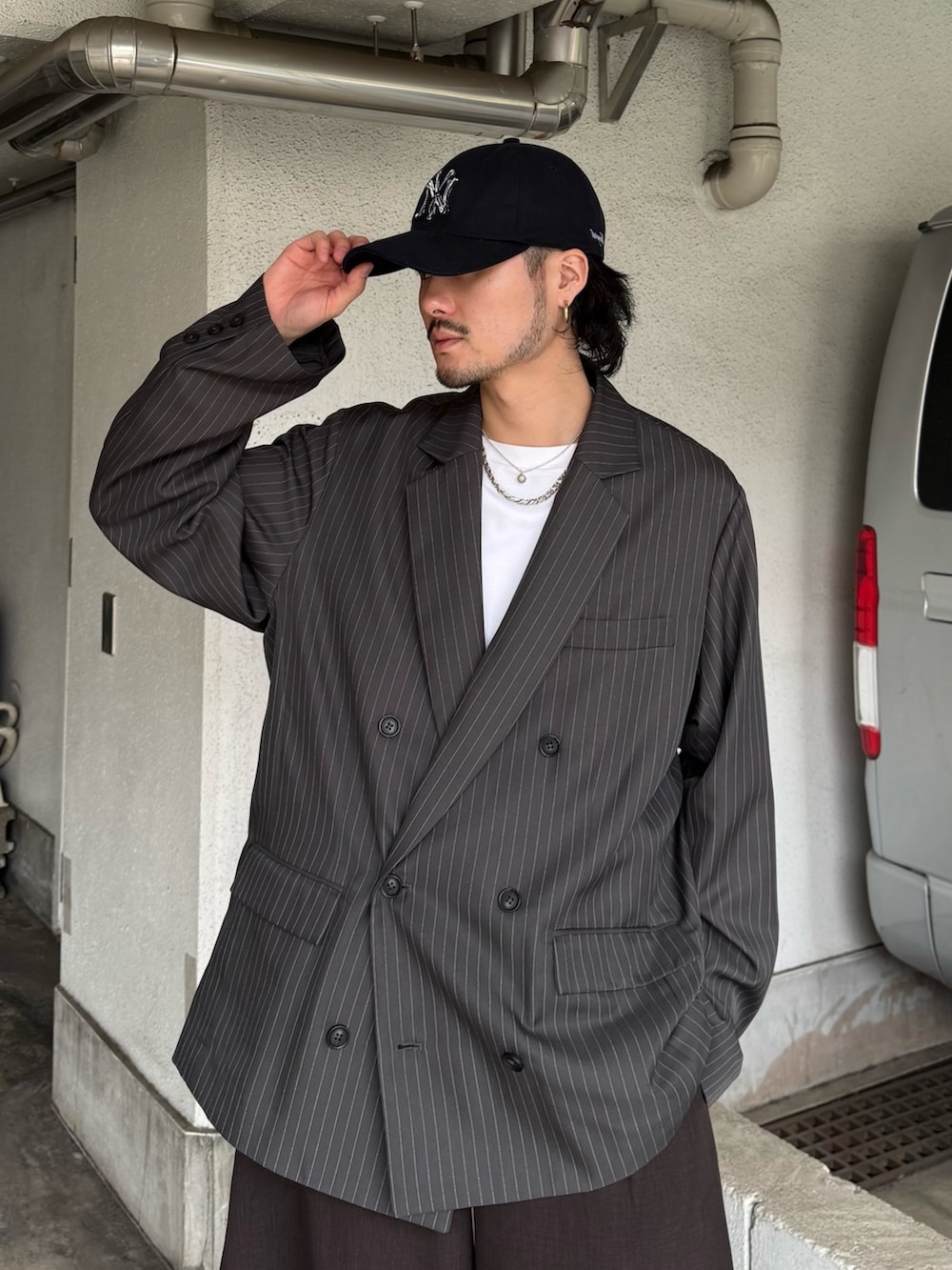 グレー系のテーラードジャケット、グレー系のスラックス、ホワイト系のTシャツ/カットソーを着用したメンズの春コーディネートの5枚目の写真