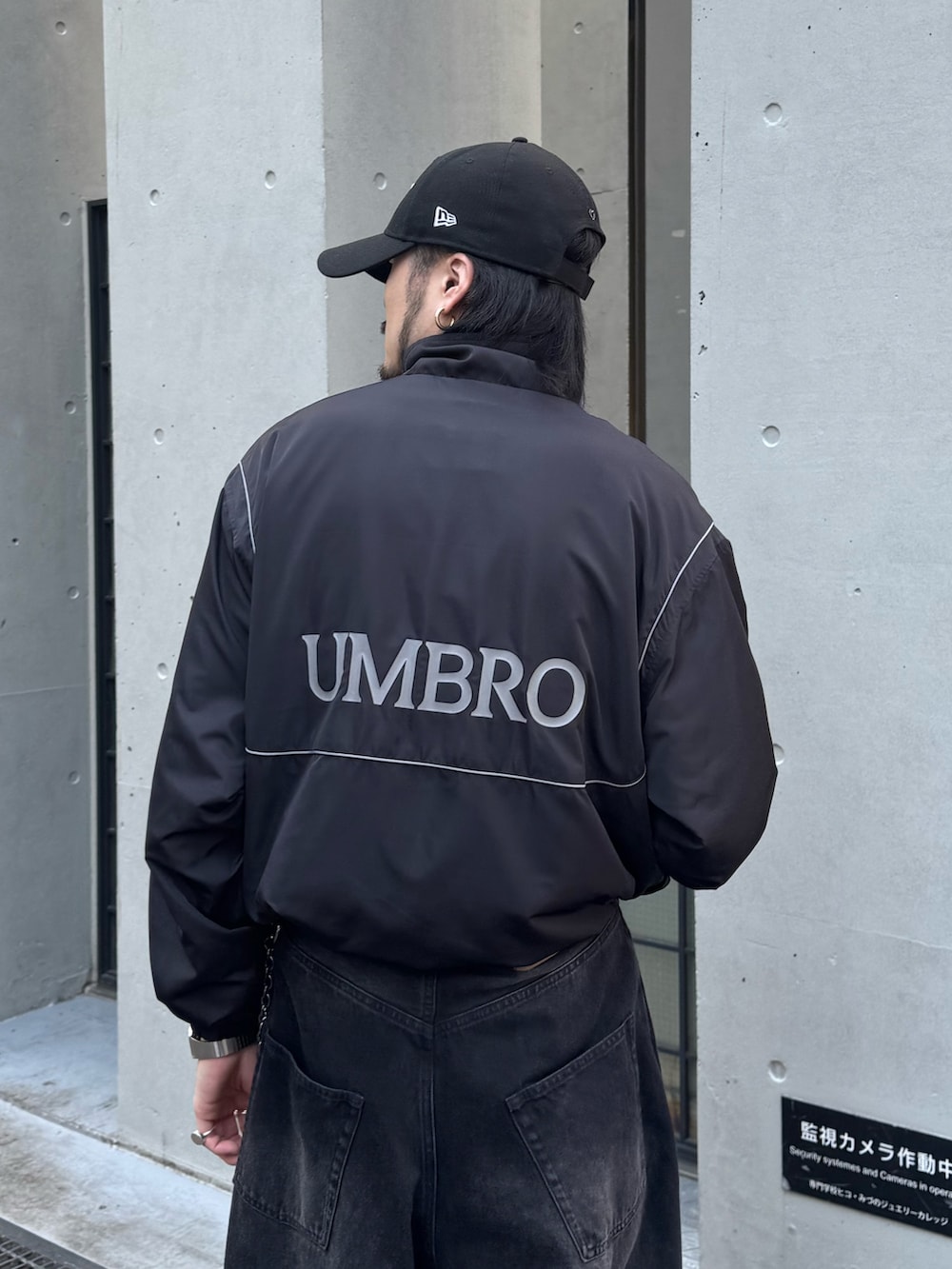 ブラック系のデニムパンツ、ブラック系のその他シューズ、ブラック系のブルゾンを着用したメンズの春コーディネートの4枚目の写真