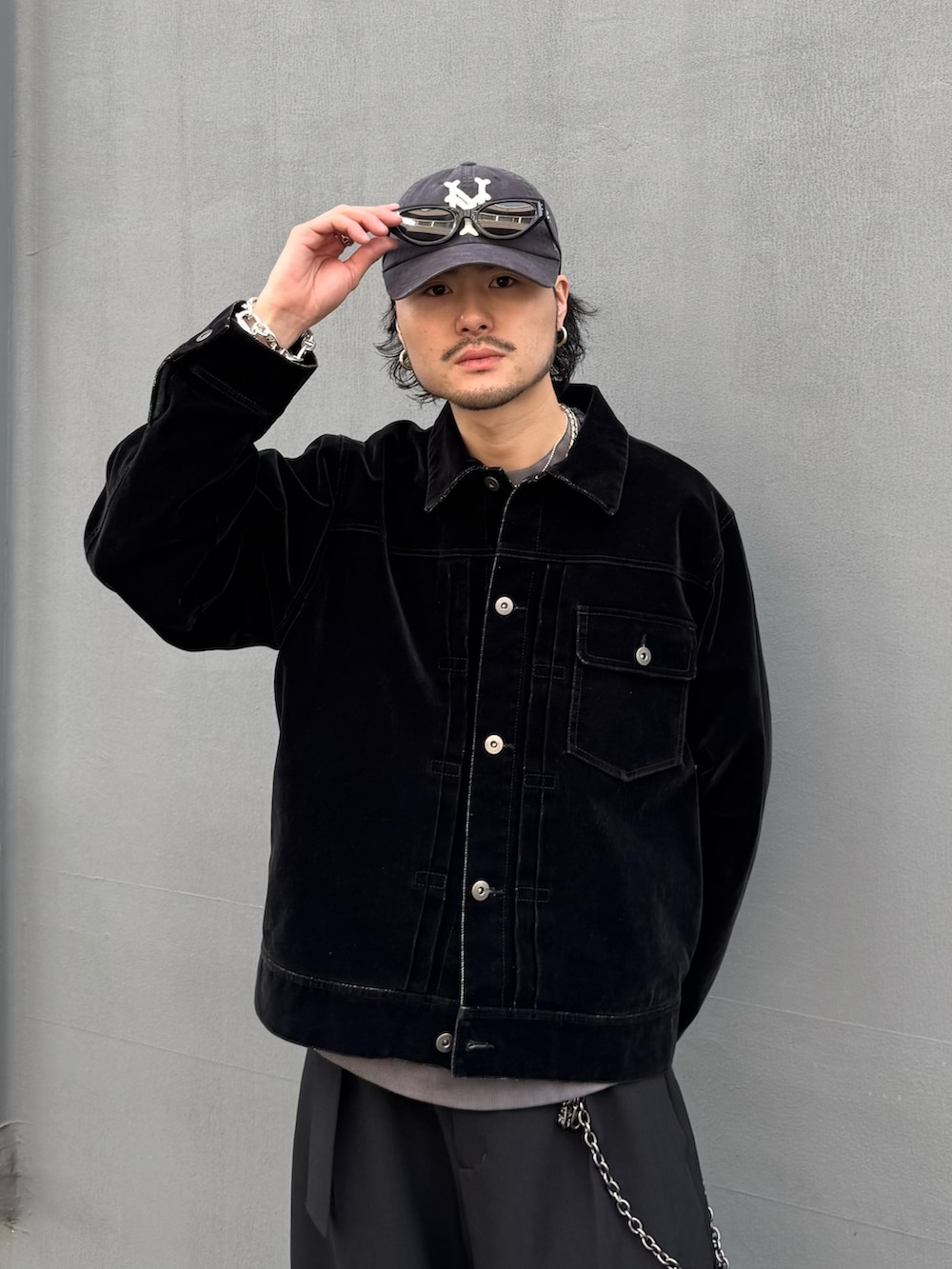 ブラック系のデニムジャケット、ブラック系のスラックス、ブラック系のウォレットチェーンを着用したメンズの春コーディネートの6枚目の写真