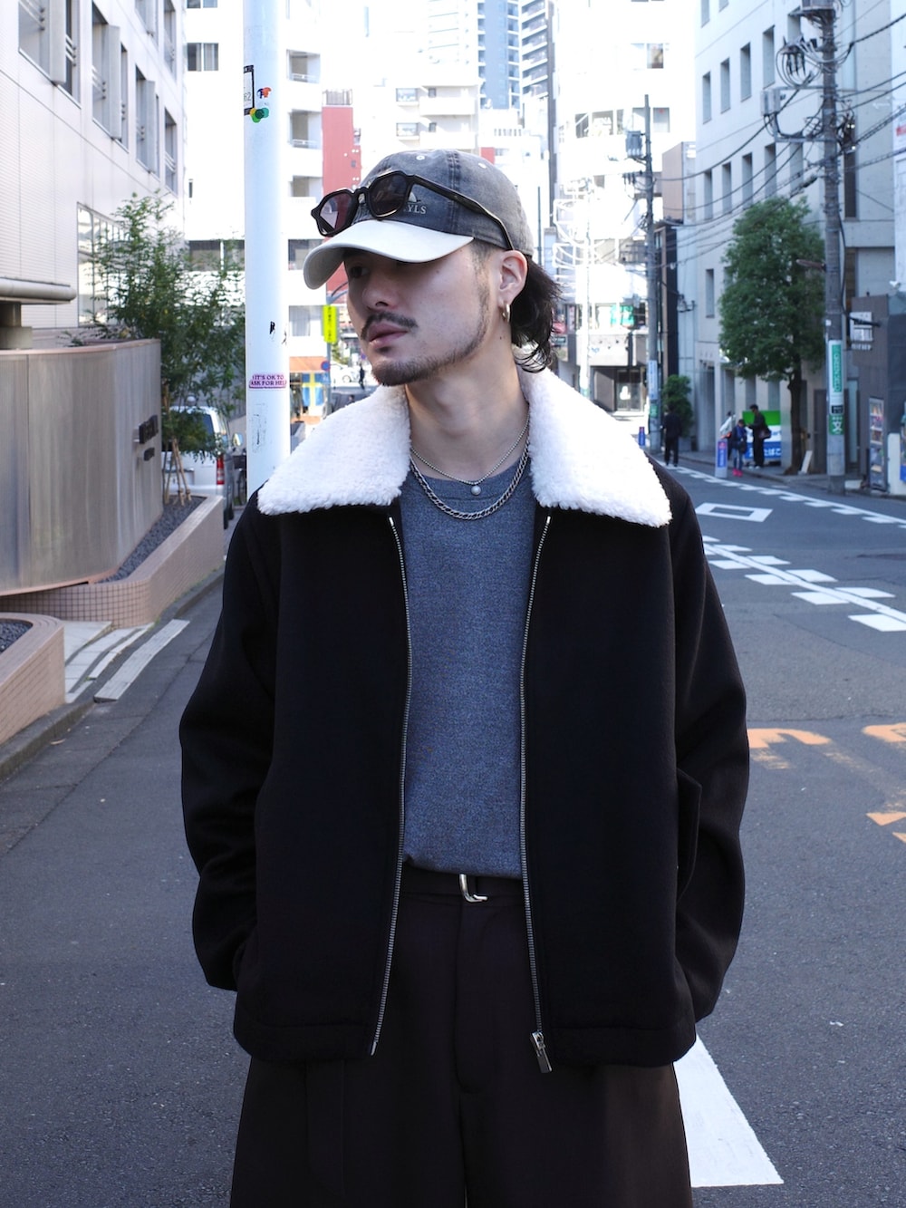 グレー系のニット/セーター、ブラック系のブルゾン、グレー系のスラックスを着用したメンズの秋コーディネートの5枚目の写真