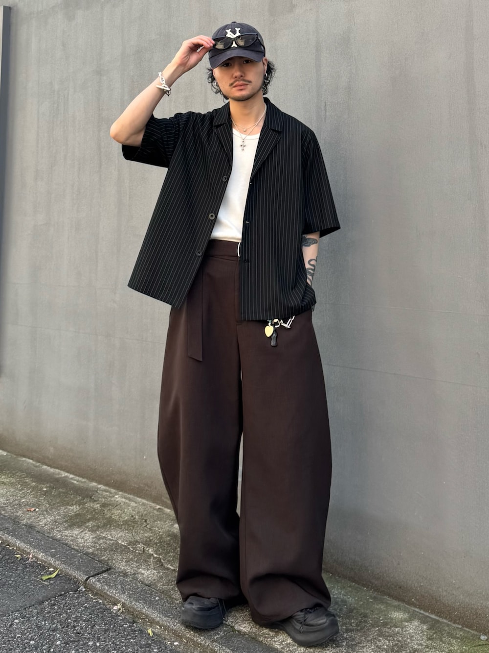 ブラック系のシャツ/ブラウス、グレー系のスラックスを着用したメンズの春コーディネートの2枚目の写真