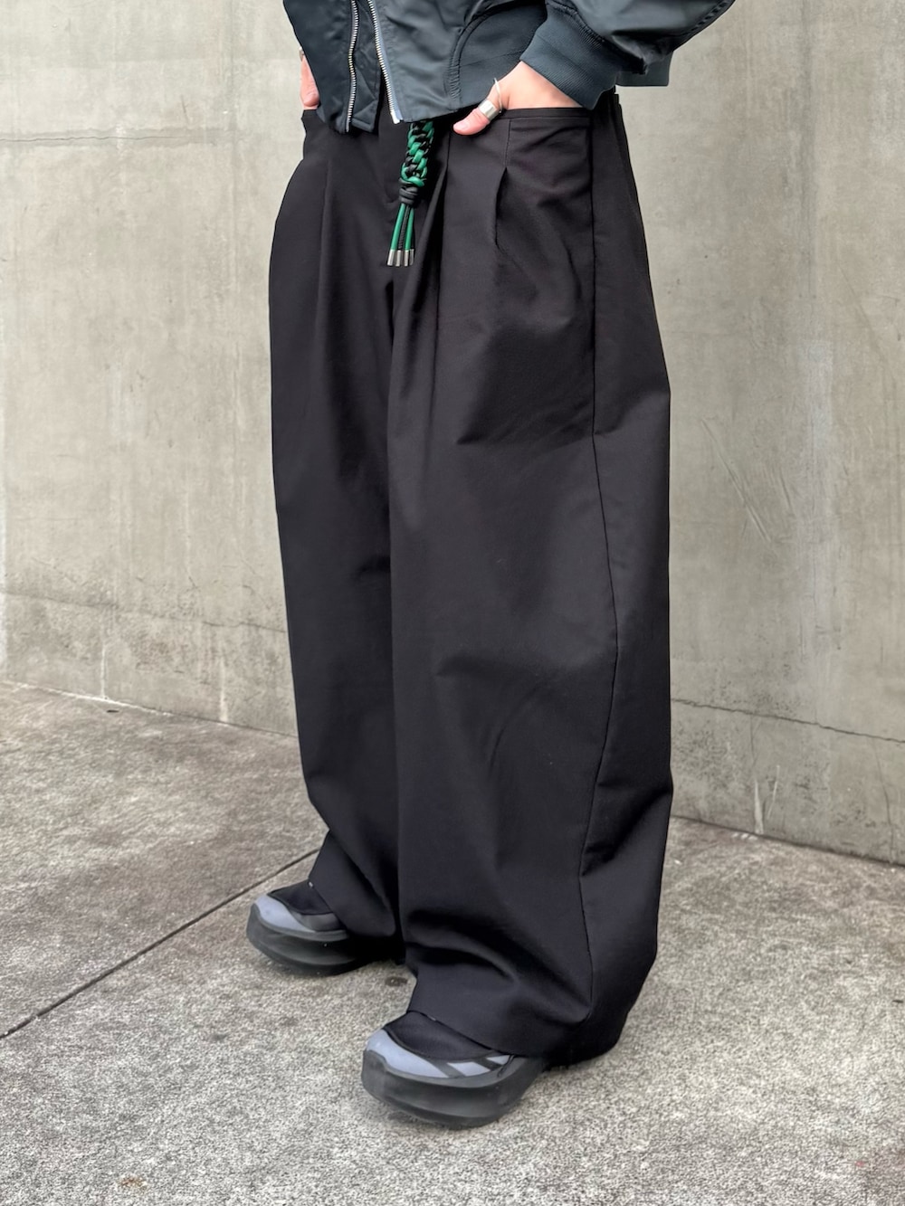 グリーン系のブルゾン、ブラック系のその他パンツ、ブラック系のキーホルダーを着用したメンズの冬コーディネートの9枚目の写真