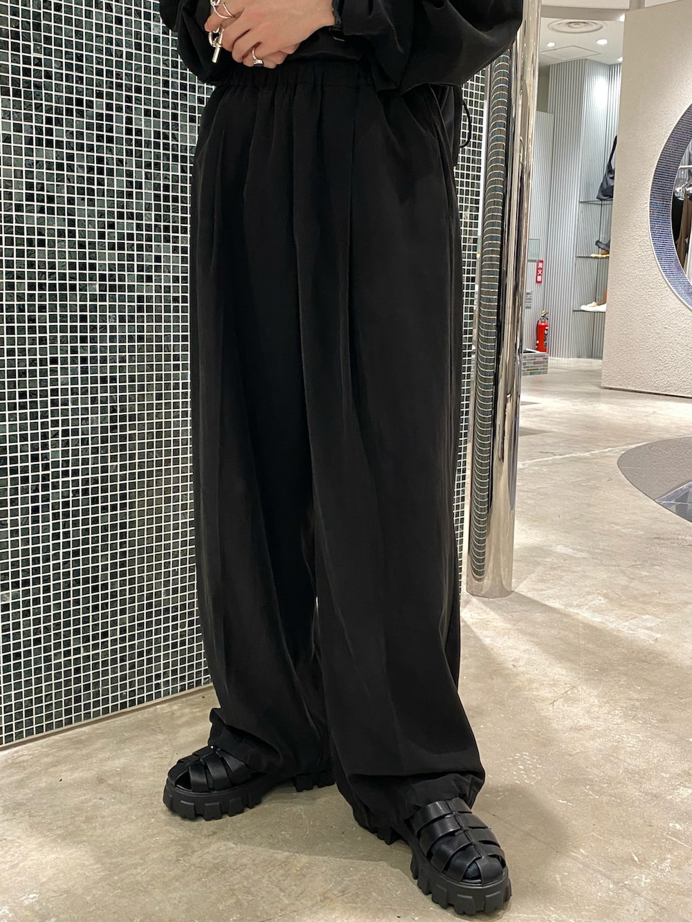 ブラック系のシャツ/ブラウス、ブラック系のスラックス、ブラック系のサンダルを着用したメンズの春コーディネートの4枚目の写真