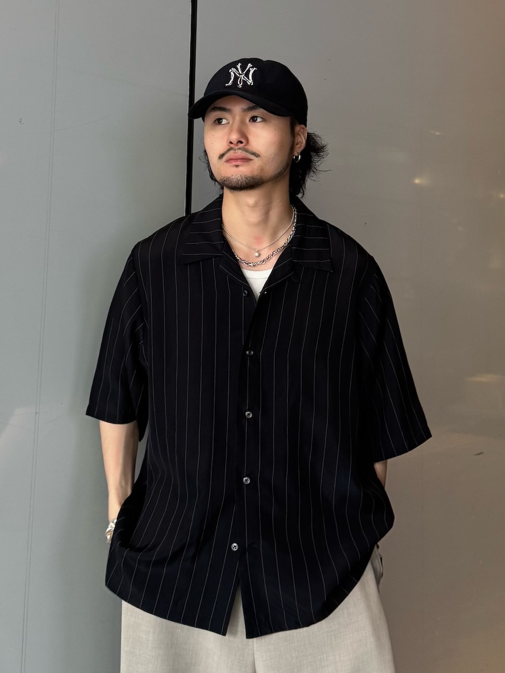 ブラック系のシャツ/ブラウス、ベージュ系のスラックスを着用したメンズの春コーディネートの4枚目の写真