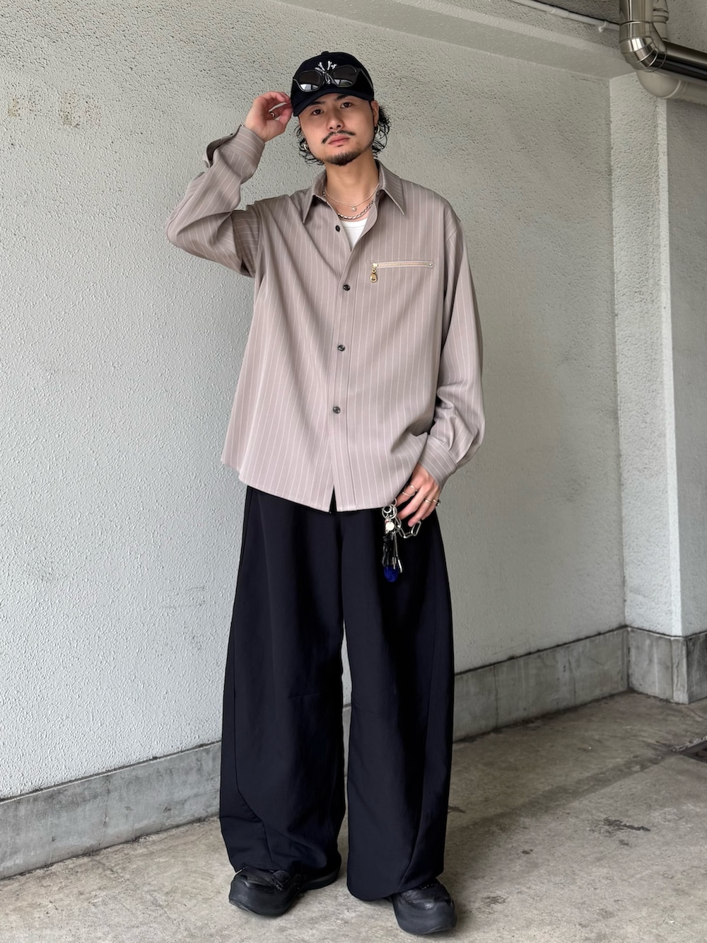 ベージュ系のシャツ/ブラウス、ブラック系のスラックスを着用したメンズの夏コーディネートの2枚目の写真