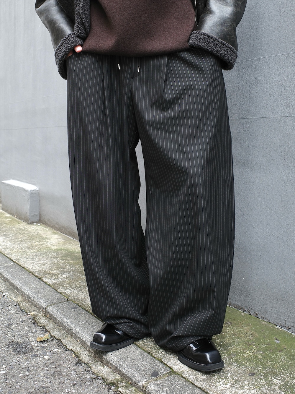 ブラック系のブルゾン、ブラック系のスラックスを着用したメンズの秋コーディネートの9枚目の写真