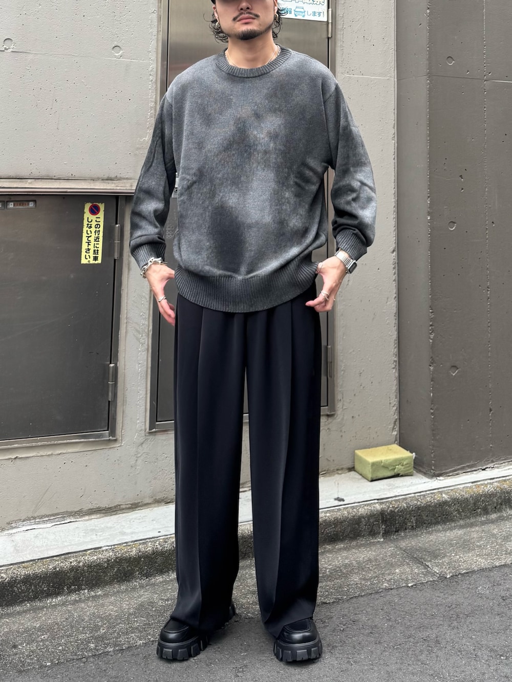 グレー系のニット/セーター、ブラック系のスラックスを着用したメンズの夏コーディネートの2枚目の写真