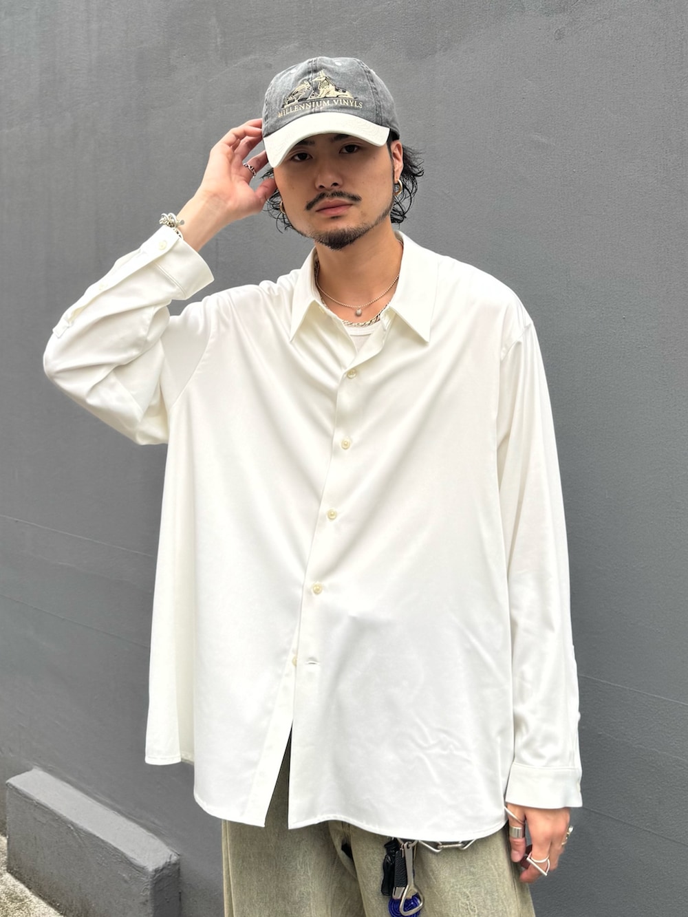 ホワイト系のトップス、グリーン系のデニムパンツを着用したメンズの夏コーディネートの4枚目の写真