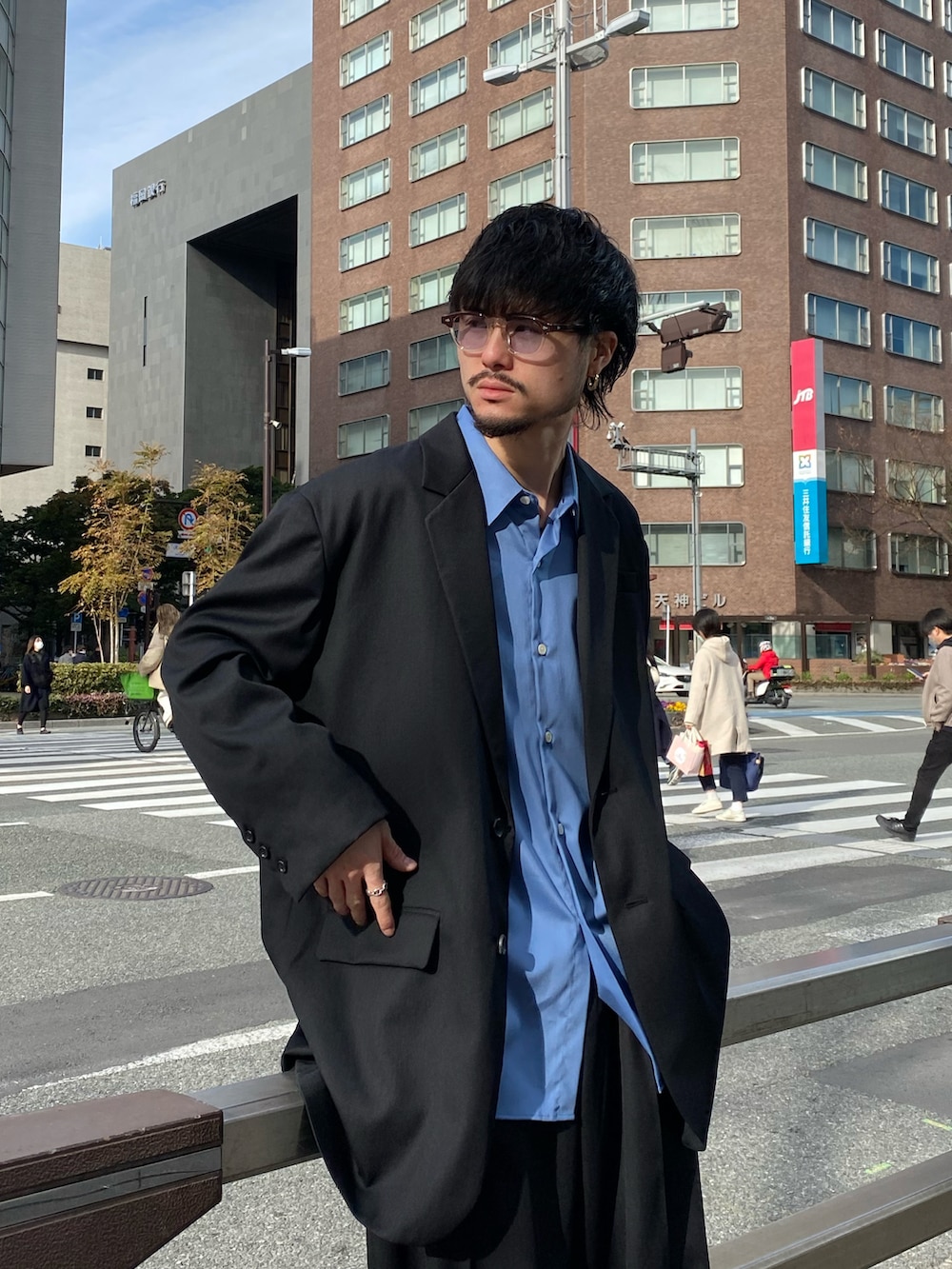 ブラック系のテーラードジャケット、ブラック系のスラックス、ブルー系のシャツ/ブラウスを着用したメンズの冬コーディネートの4枚目の写真