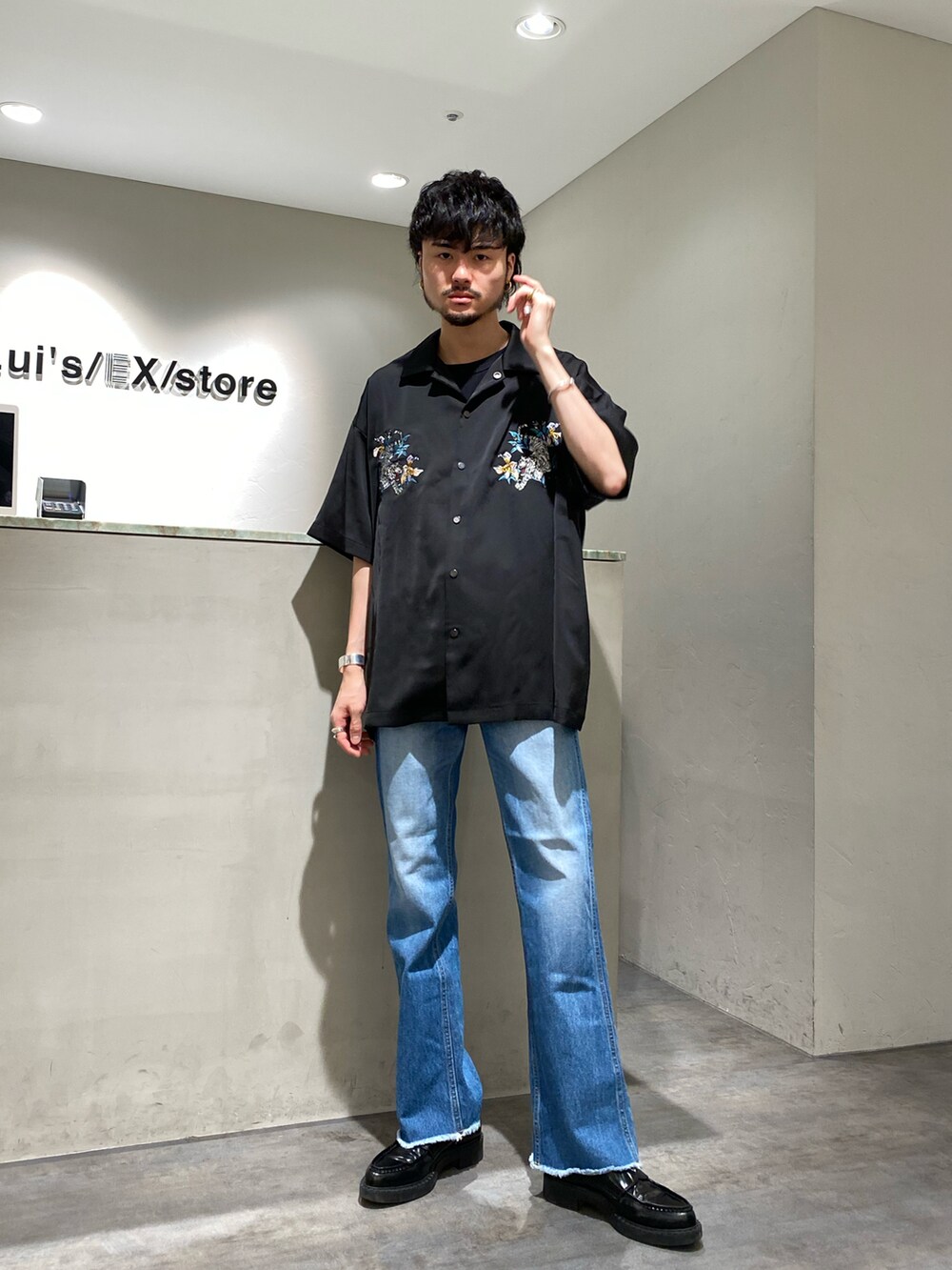 ブラック系のシャツ/ブラウス、ブルー系のデニムパンツ、シルバー系のバングル/リストバンドを着用したメンズの春コーディネートの2枚目の写真