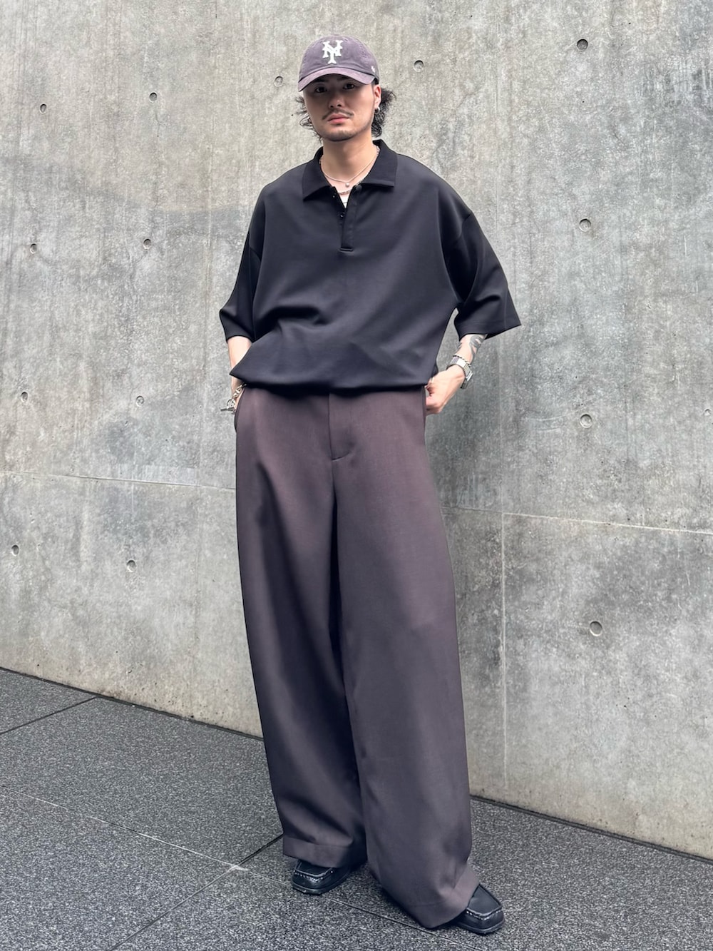 ブラック系のTシャツ/カットソー、ブラウン系のスラックスを着用したメンズの夏コーディネートの2枚目の写真