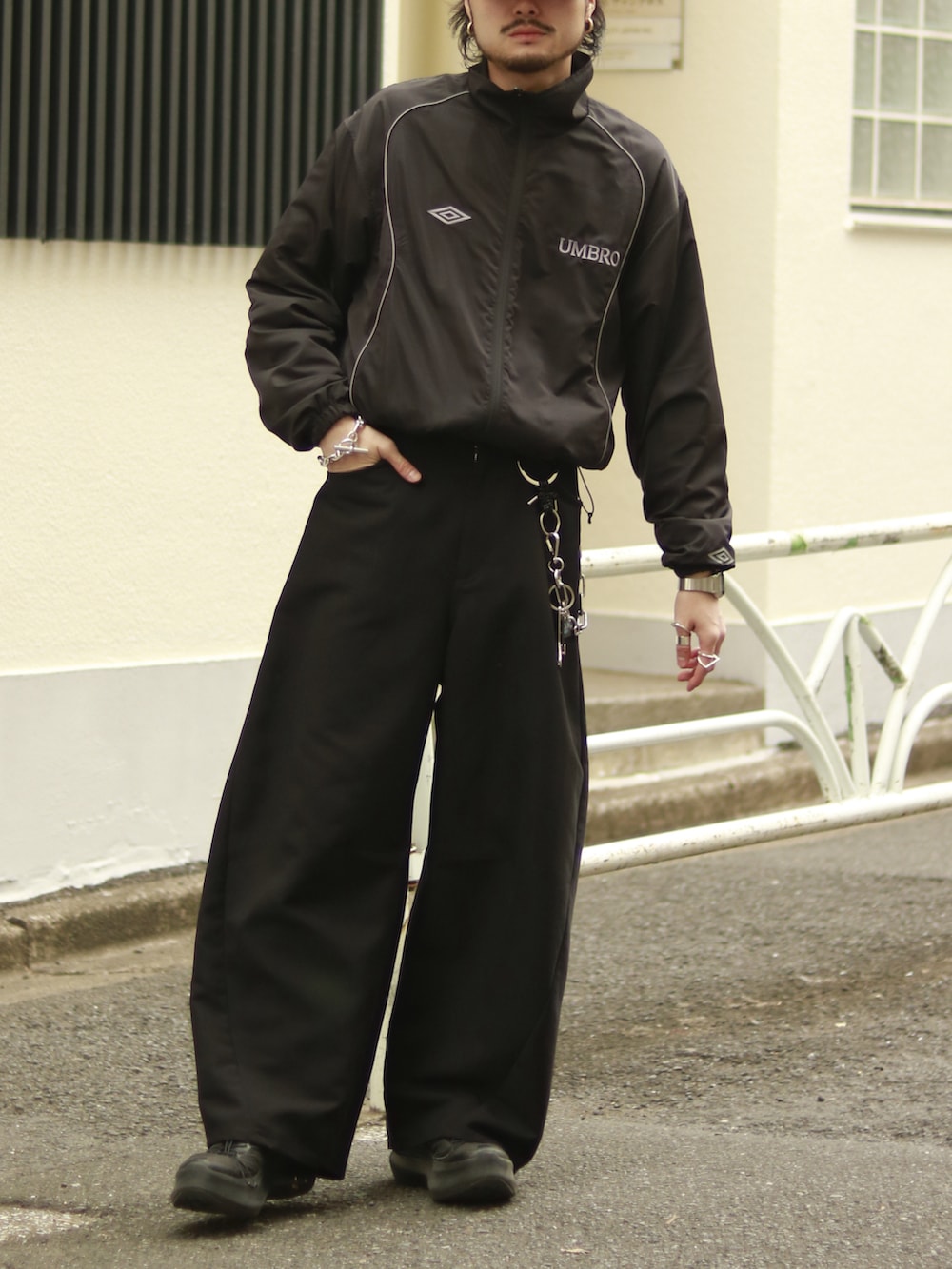 ブラック系のブルゾン、ブラック系のスラックス、ブラック系のキーホルダーを着用したメンズの冬コーディネートの2枚目の写真