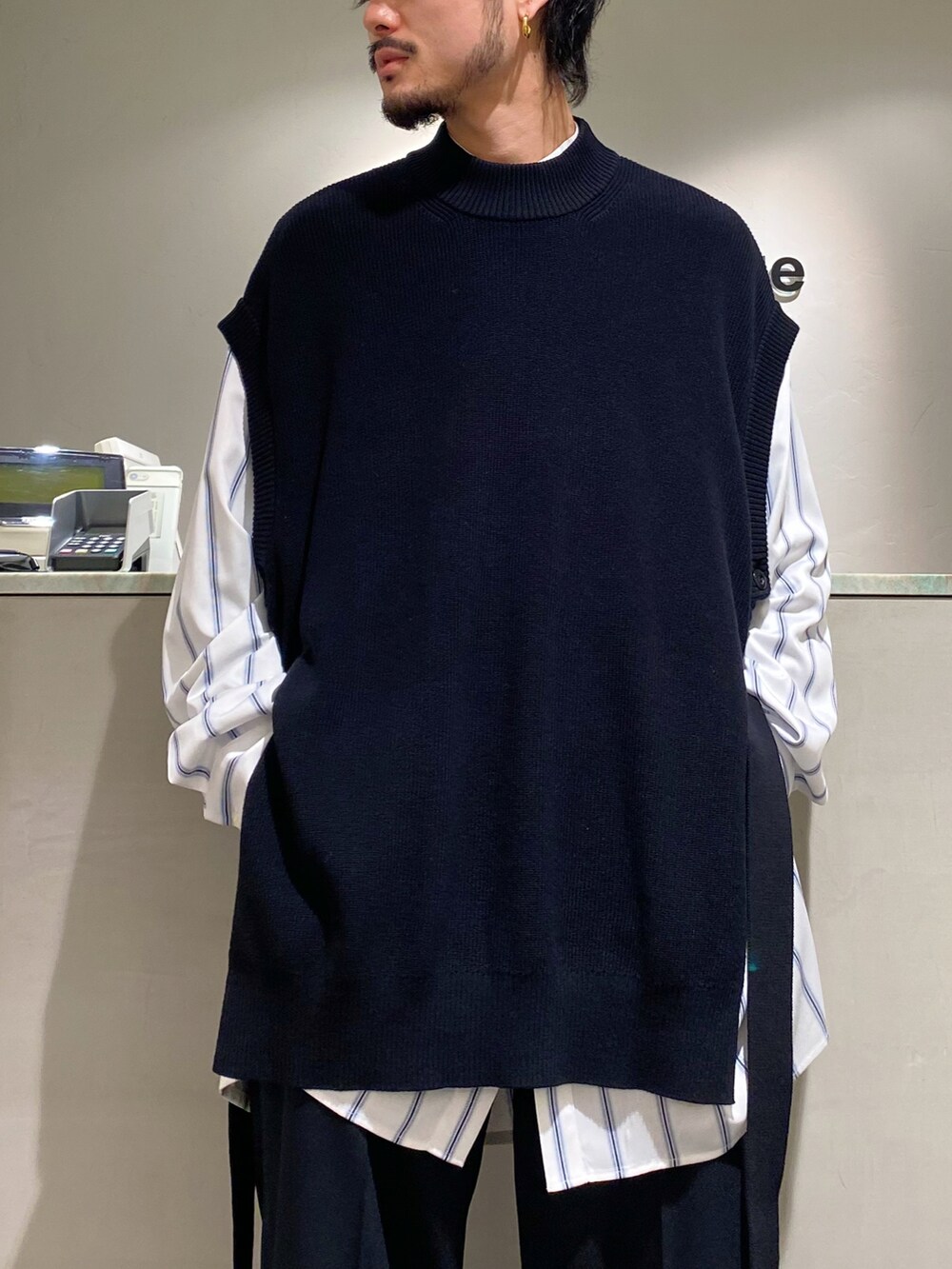 ブラック系のベスト、ホワイト系のシャツ/ブラウス、ブラック系のスラックスを着用したメンズの春コーディネートの3枚目の写真