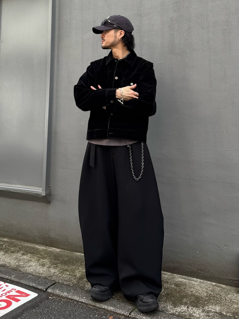 ブラック系のデニムジャケット、ブラック系のスラックス、ブラック系のウォレットチェーンを着用したメンズの春コーディネートの3枚目の写真