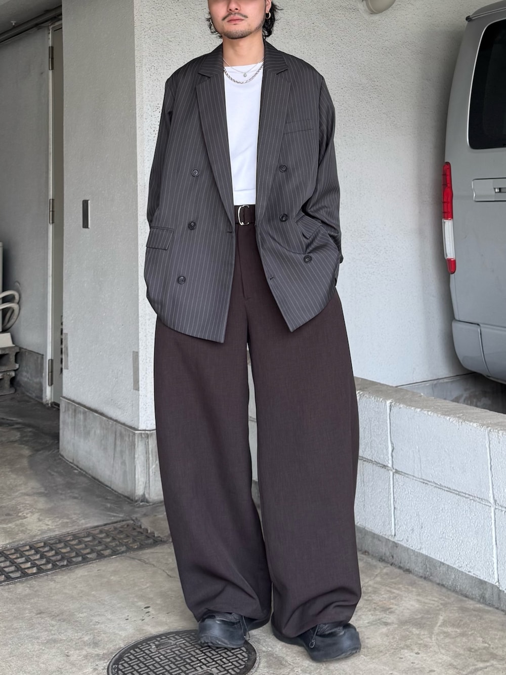 グレー系のテーラードジャケット、グレー系のスラックス、ホワイト系のTシャツ/カットソーを着用したメンズの春コーディネートの4枚目の写真