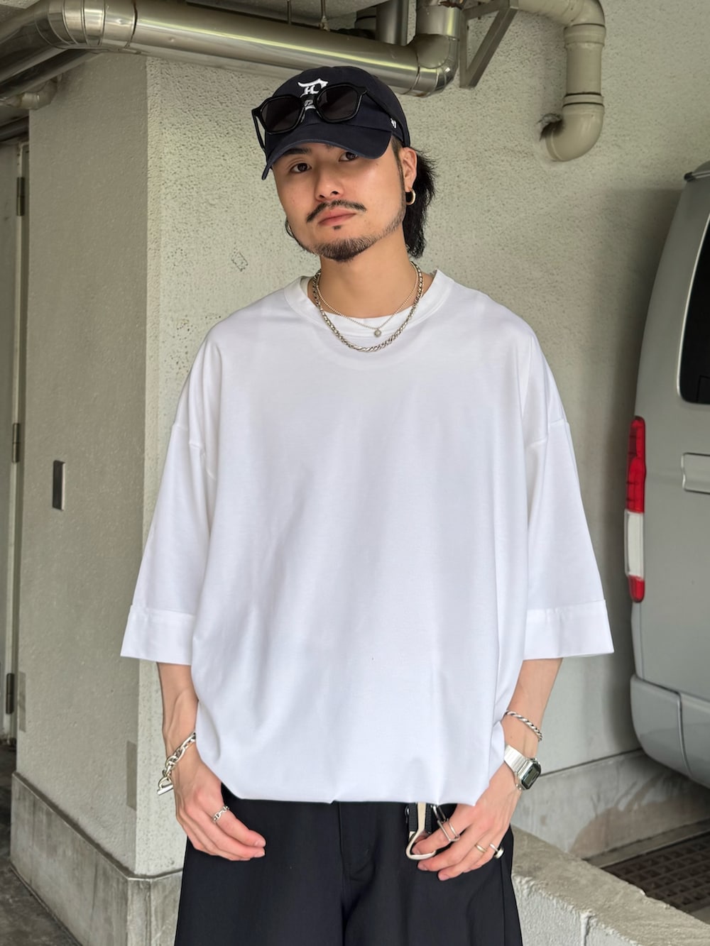 ホワイト系のTシャツ/カットソー、ブラック系のスラックスを着用したメンズの夏コーディネートの3枚目の写真