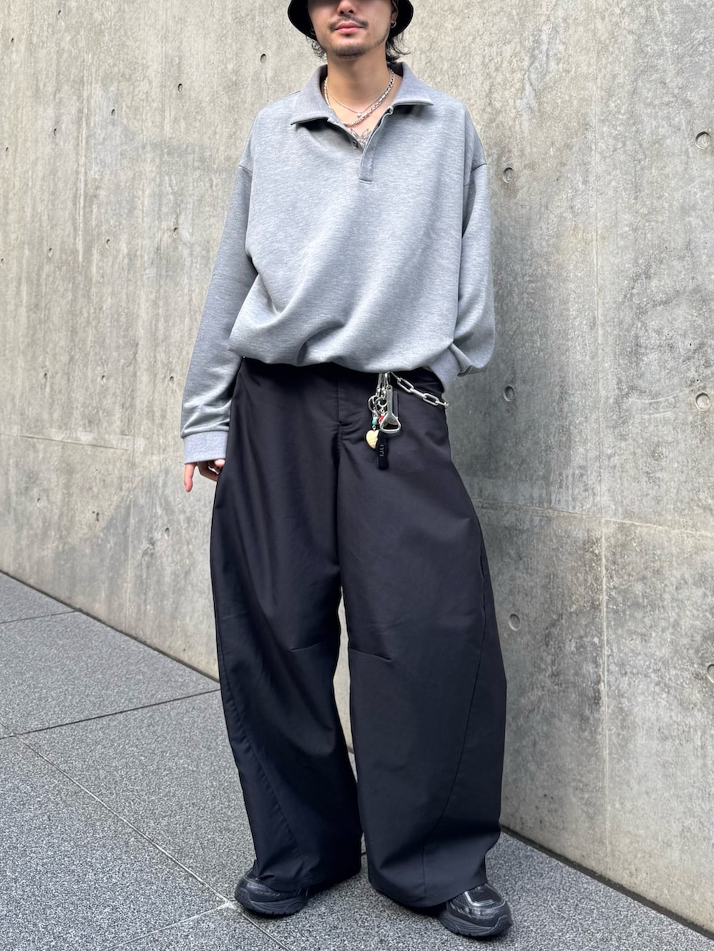 グレー系のポロシャツ、ブラック系のスラックスを着用したメンズの秋コーディネートの2枚目の写真