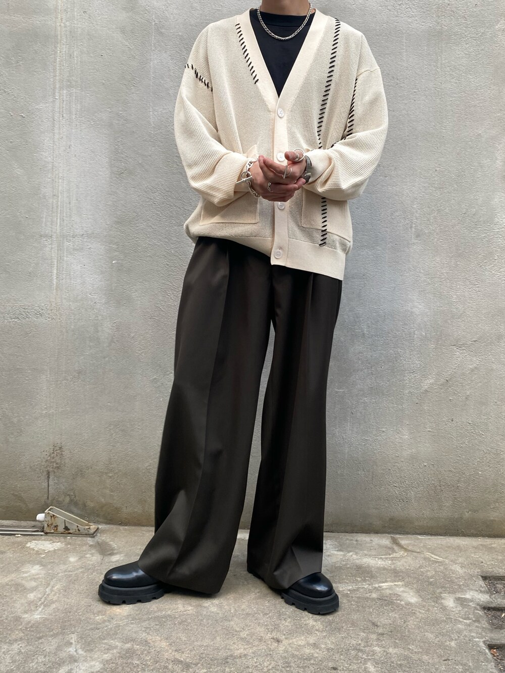 ホワイト系のカーディガン/ボレロ、グリーン系のスラックス、ブラック系のドレスシューズを着用したメンズの春コーディネートの3枚目の写真