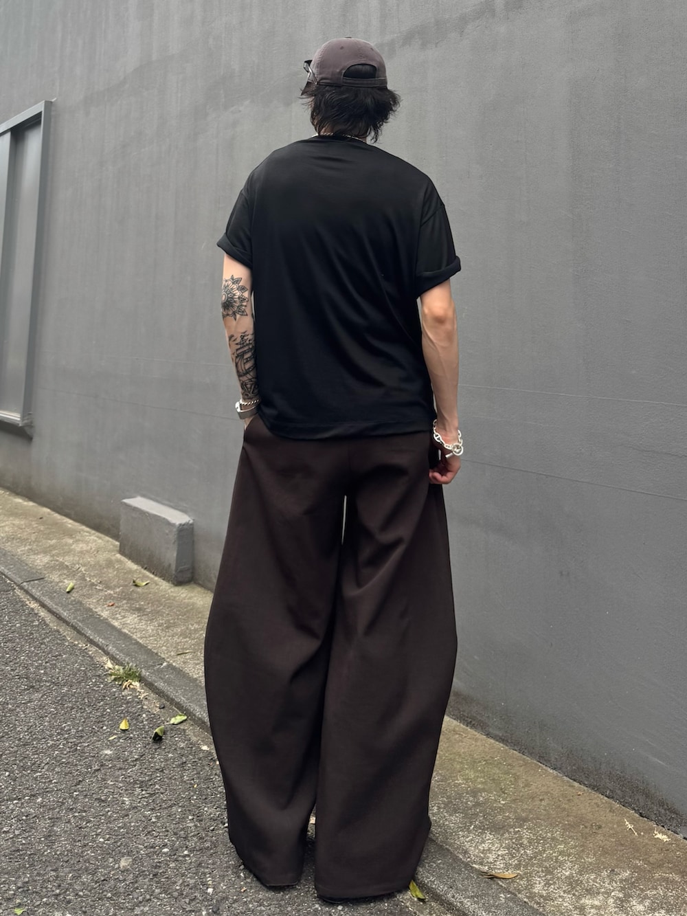 ブラック系のTシャツ/カットソー、グレー系のスラックスを着用したメンズの夏コーディネートの3枚目の写真