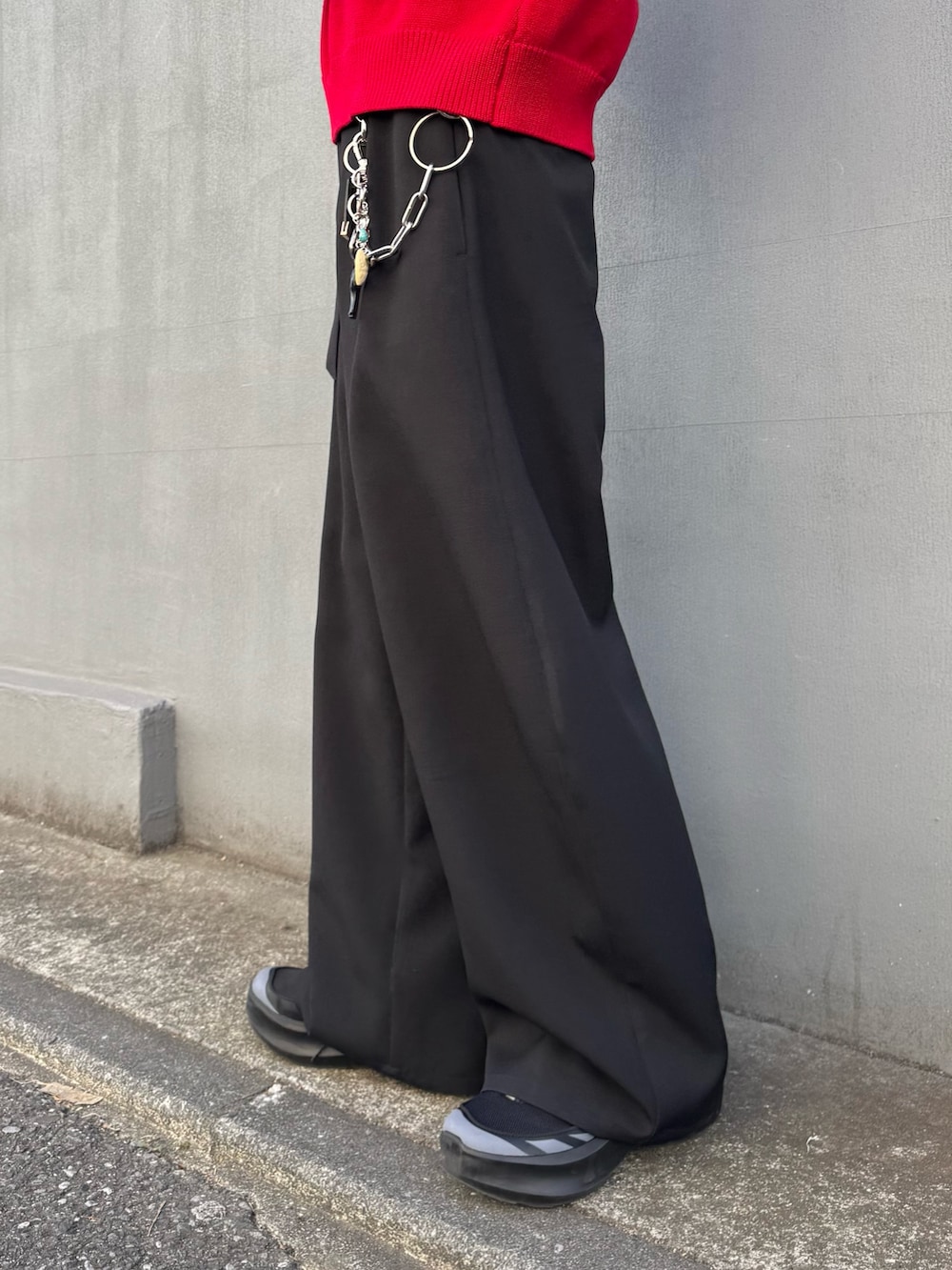 レッド系のニット/セーター、ブラック系のスラックスを着用したメンズの冬コーディネートの7枚目の写真