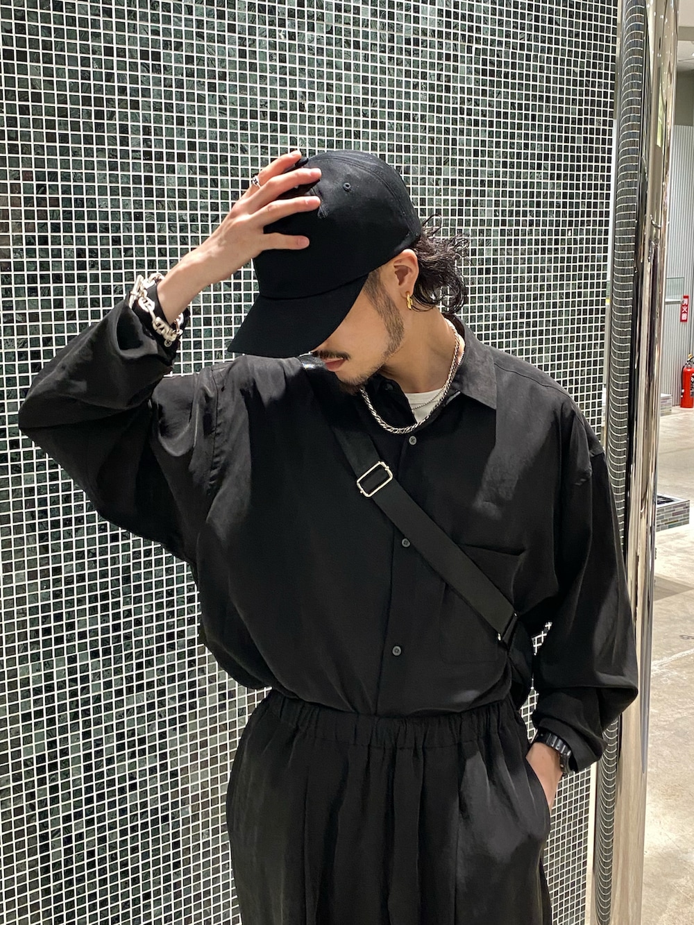 ブラック系のシャツ/ブラウス、ブラック系のスラックス、ブラック系のサンダルを着用したメンズの春コーディネートの3枚目の写真