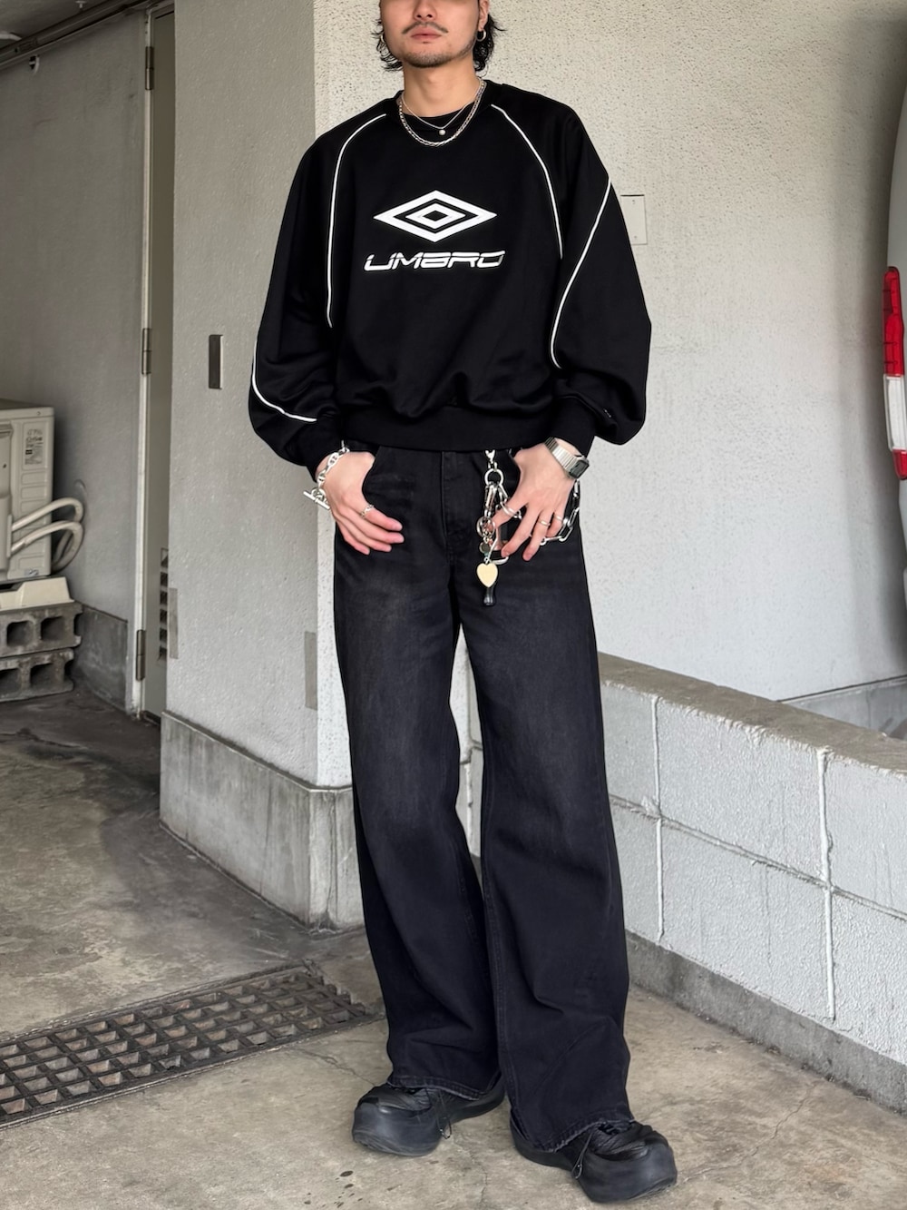 ブラック系のスウェット、ブラック系のデニムパンツを着用したメンズの春コーディネートの3枚目の写真