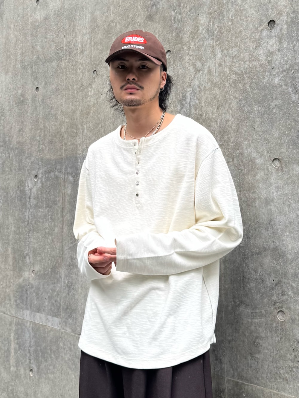 ホワイト系のTシャツ/カットソー、ブラウン系のスラックス、ブラック系のローファーを着用したメンズの秋コーディネートの3枚目の写真
