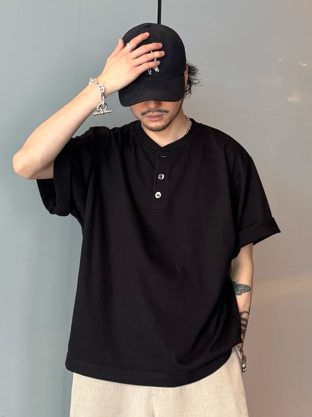 ブラック系のTシャツ/カットソー、ベージュ系のスラックスを着用したメンズの春コーディネートの5枚目の写真