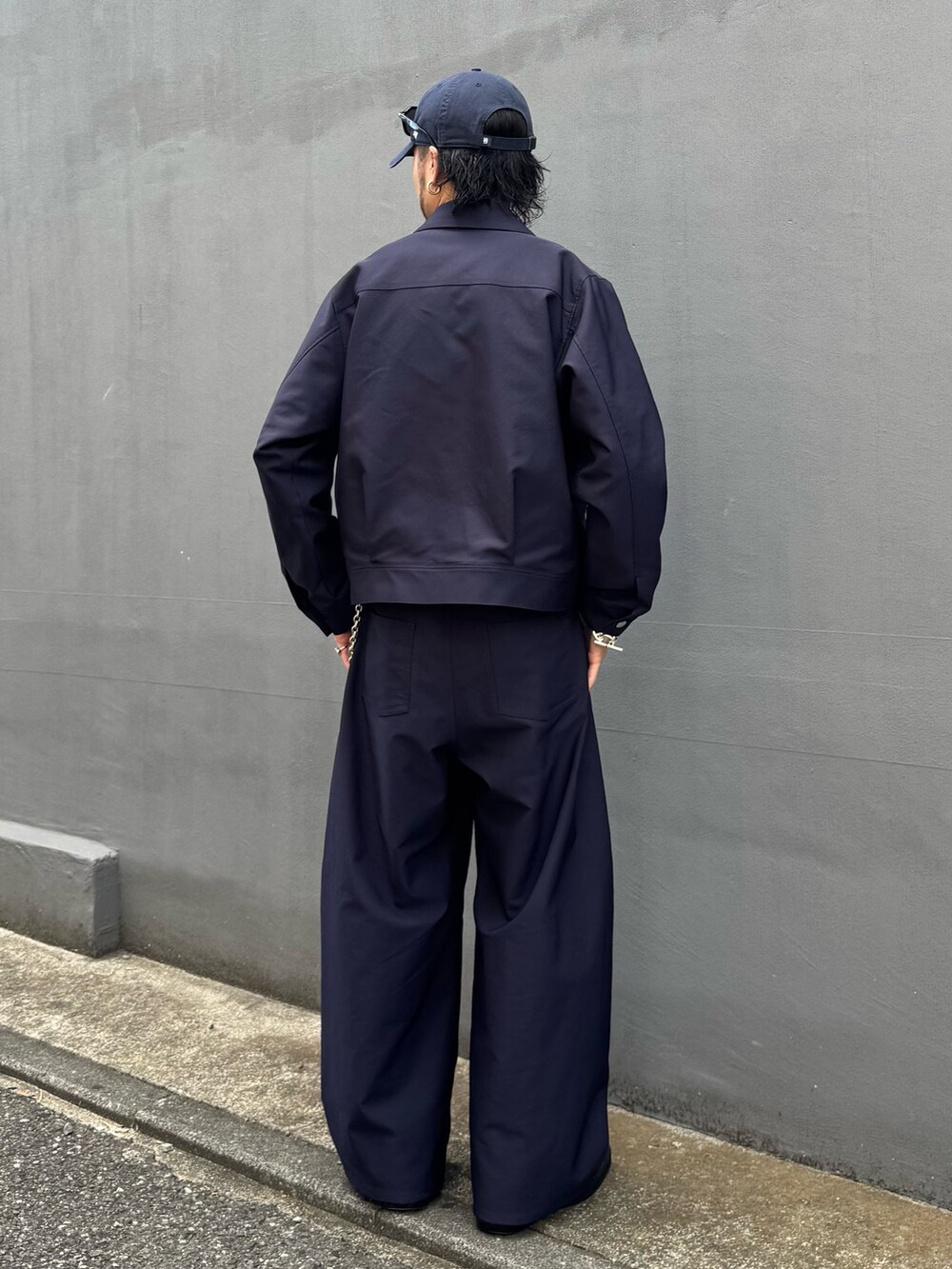 ブルー系のブルゾン、ブルー系のスラックス、シルバー系のウォレットチェーンを着用したメンズの夏コーディネートの3枚目の写真