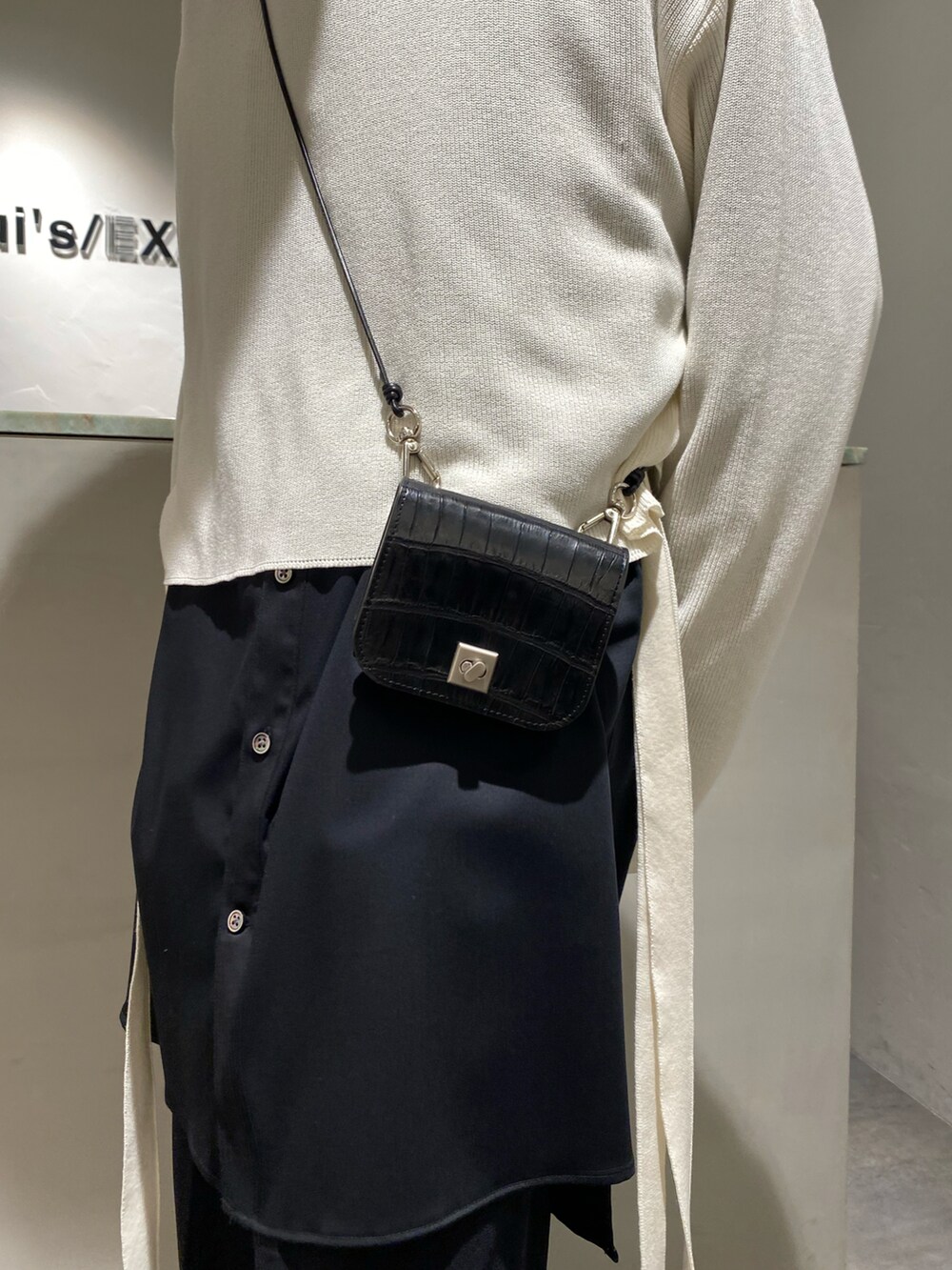 ベージュ系のトップス、ブラック系のシャツ/ブラウス、ブラック系のスラックスを着用したメンズの春コーディネートの4枚目の写真