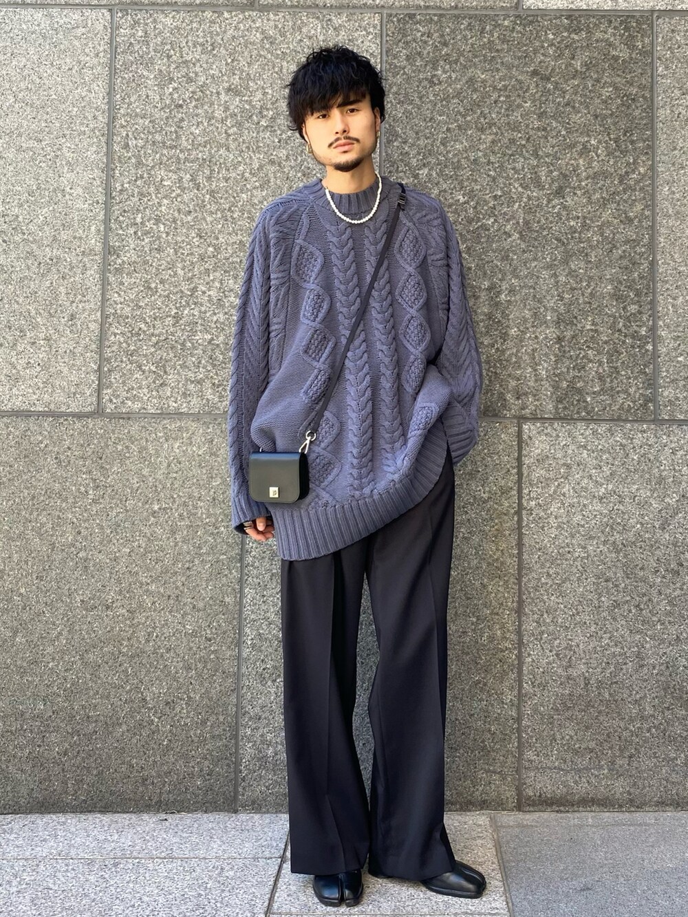 ブルー系のニット/セーター、ブラック系のスラックス、ブラック系の財布を着用したメンズの秋コーディネートの2枚目の写真