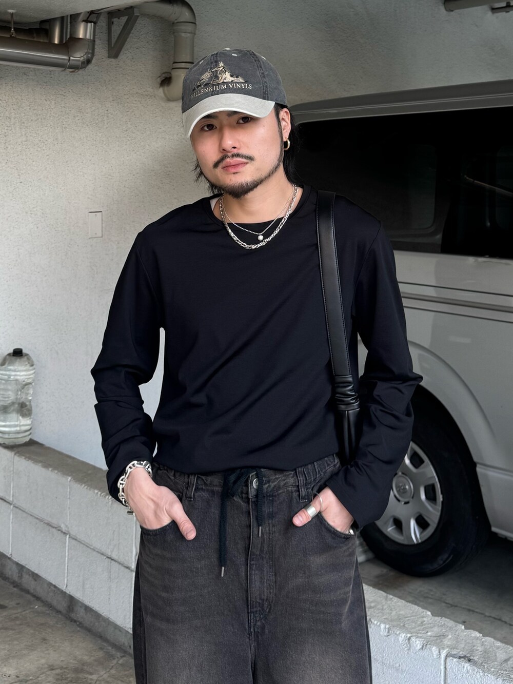 ブラック系のデニムパンツ、ブラック系のその他シューズ、ブラック系のTシャツ/カットソーを着用したメンズの春コーディネートの3枚目の写真