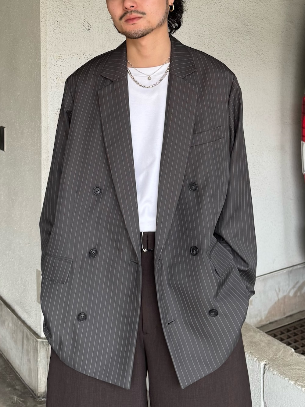 グレー系のテーラードジャケット、グレー系のスラックス、ホワイト系のTシャツ/カットソーを着用したメンズの春コーディネートの7枚目の写真