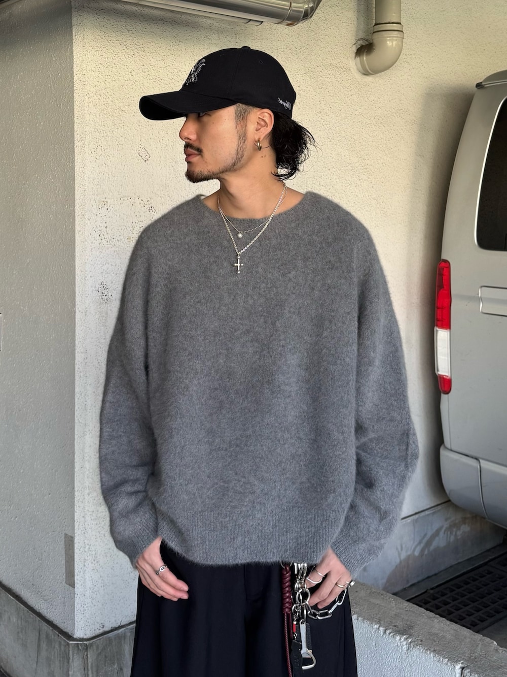 グレー系のニット/セーター、ブラック系のスラックスを着用したメンズの秋コーディネートの5枚目の写真