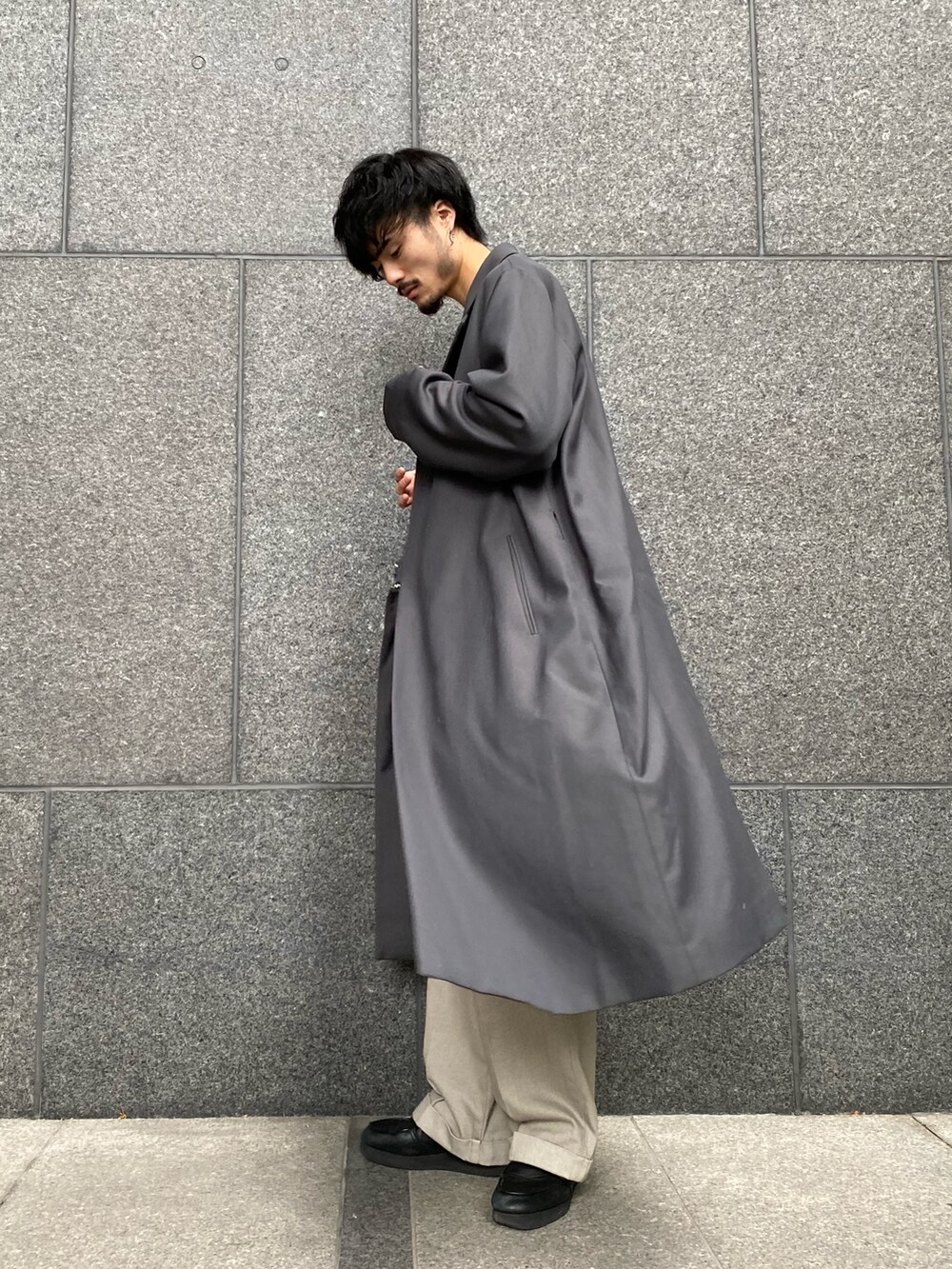 グレー系のトレンチコート、ベージュ系のデニムパンツ、ホワイト系のニット/セーターを着用したメンズの秋コーディネートの4枚目の写真