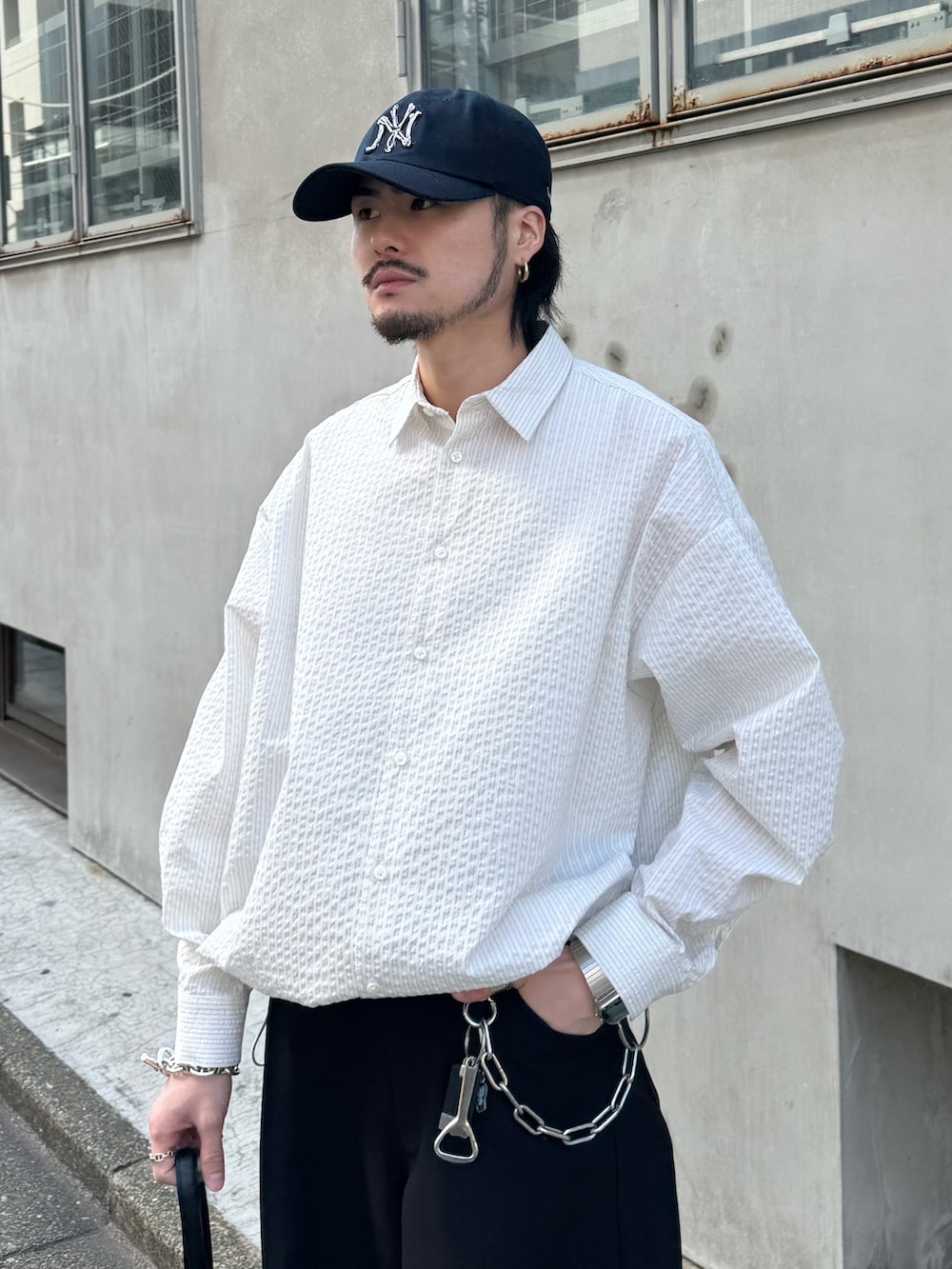 ホワイト系のシャツ/ブラウス、ブラック系のショルダーバッグ、ブラック系のスラックスを着用したメンズの春コーディネートの3枚目の写真