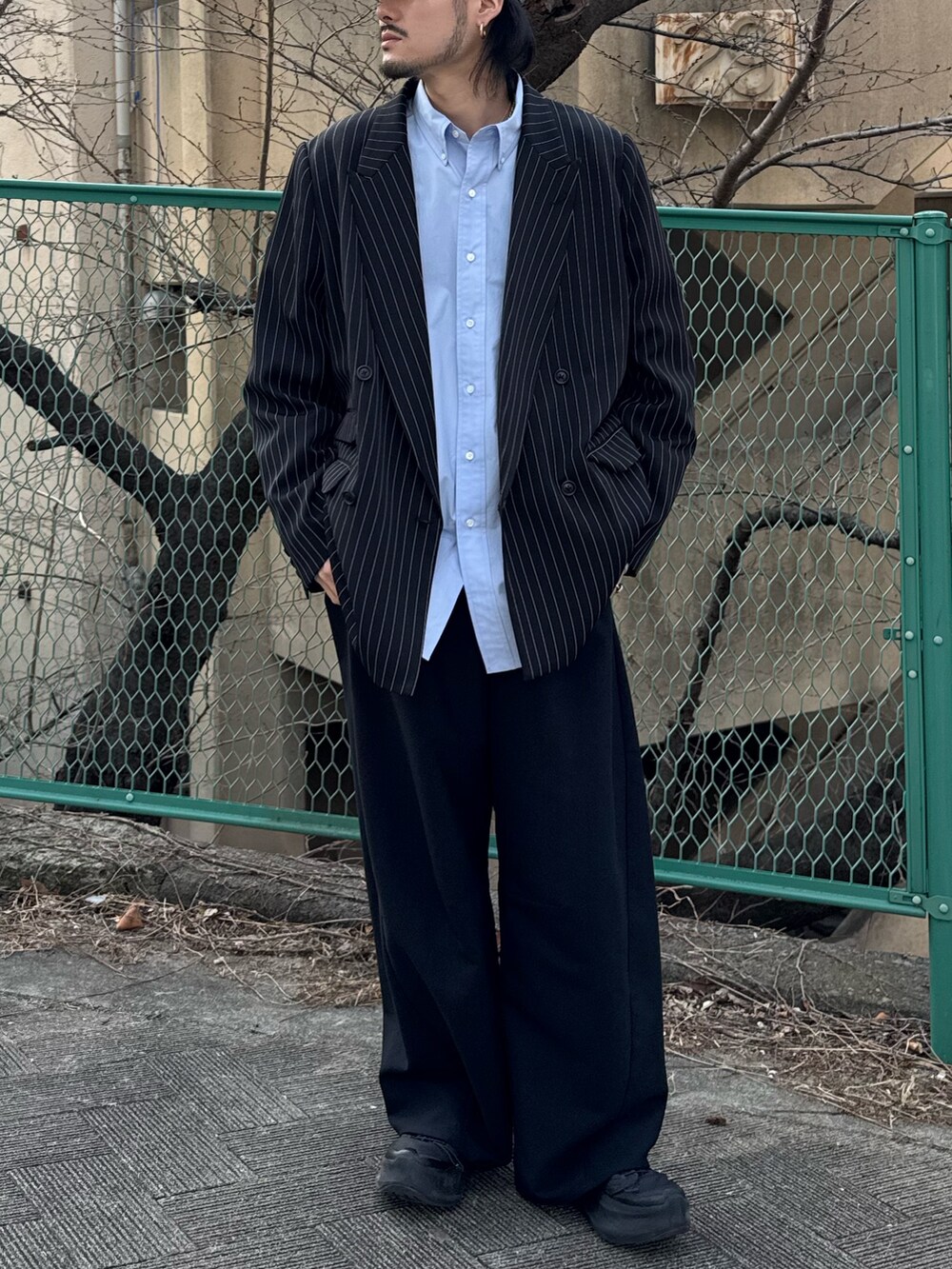 ブラック系のスラックス、ブルー系のシャツ/ブラウス、ブラック系のテーラードジャケットを着用したメンズの春コーディネートの3枚目の写真