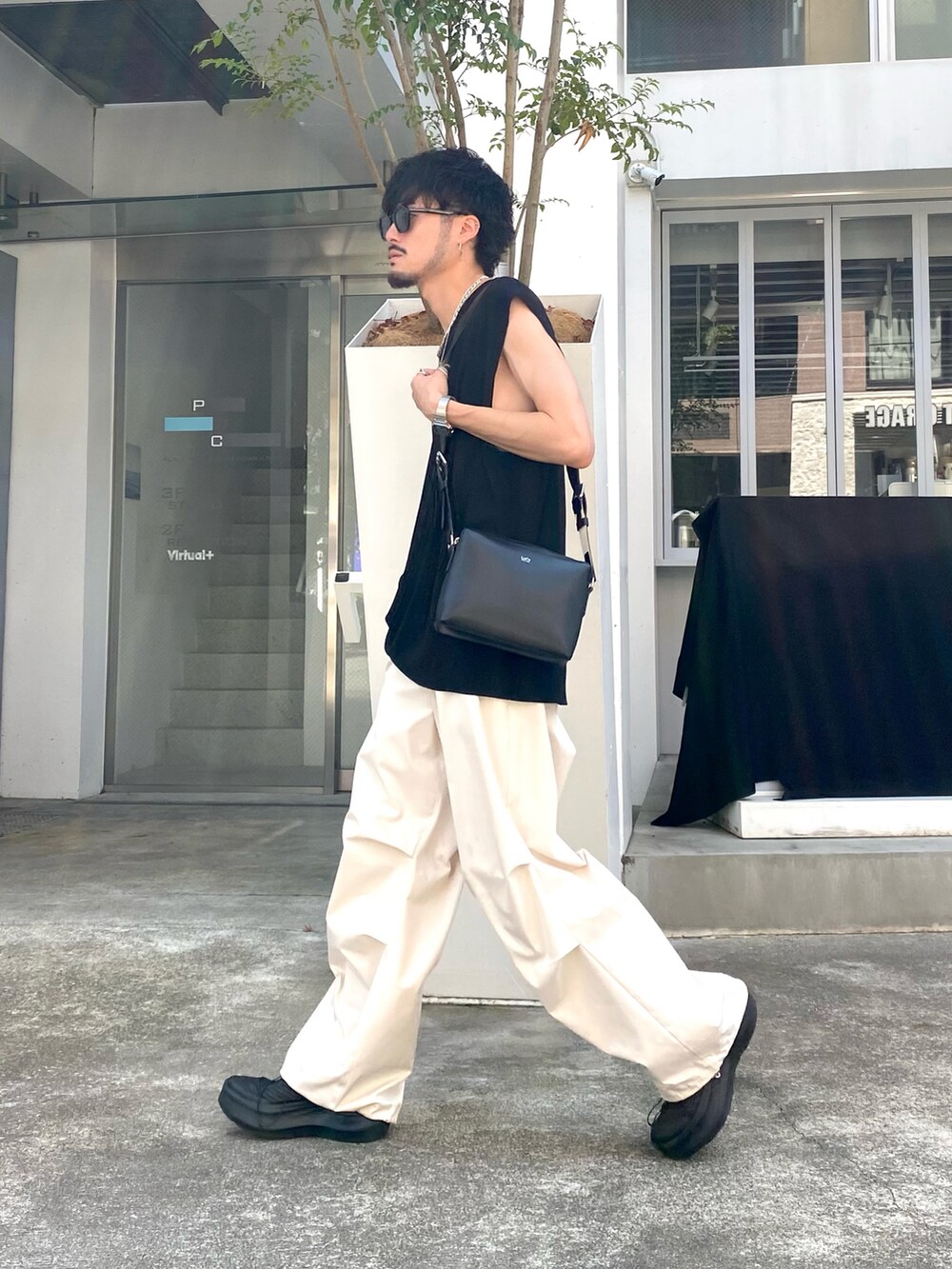 ブラック系のTシャツ/カットソー、ホワイト系のその他パンツ、ブラック系のショルダーバッグを着用したメンズの夏コーディネートの2枚目の写真
