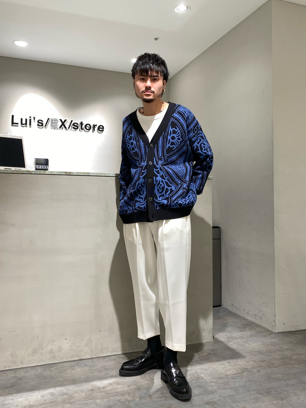 ブラック系のカーディガン/ボレロ、ホワイト系のスラックスを着用したメンズの春コーディネートの3枚目の写真