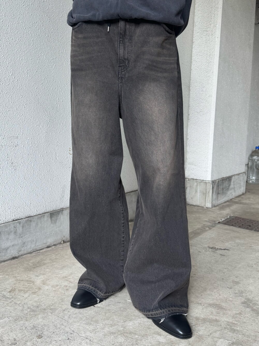 ブラック系のデニムパンツ、ブラック系のその他シューズ、グレー系のスウェットを着用したメンズの春コーディネートの4枚目の写真