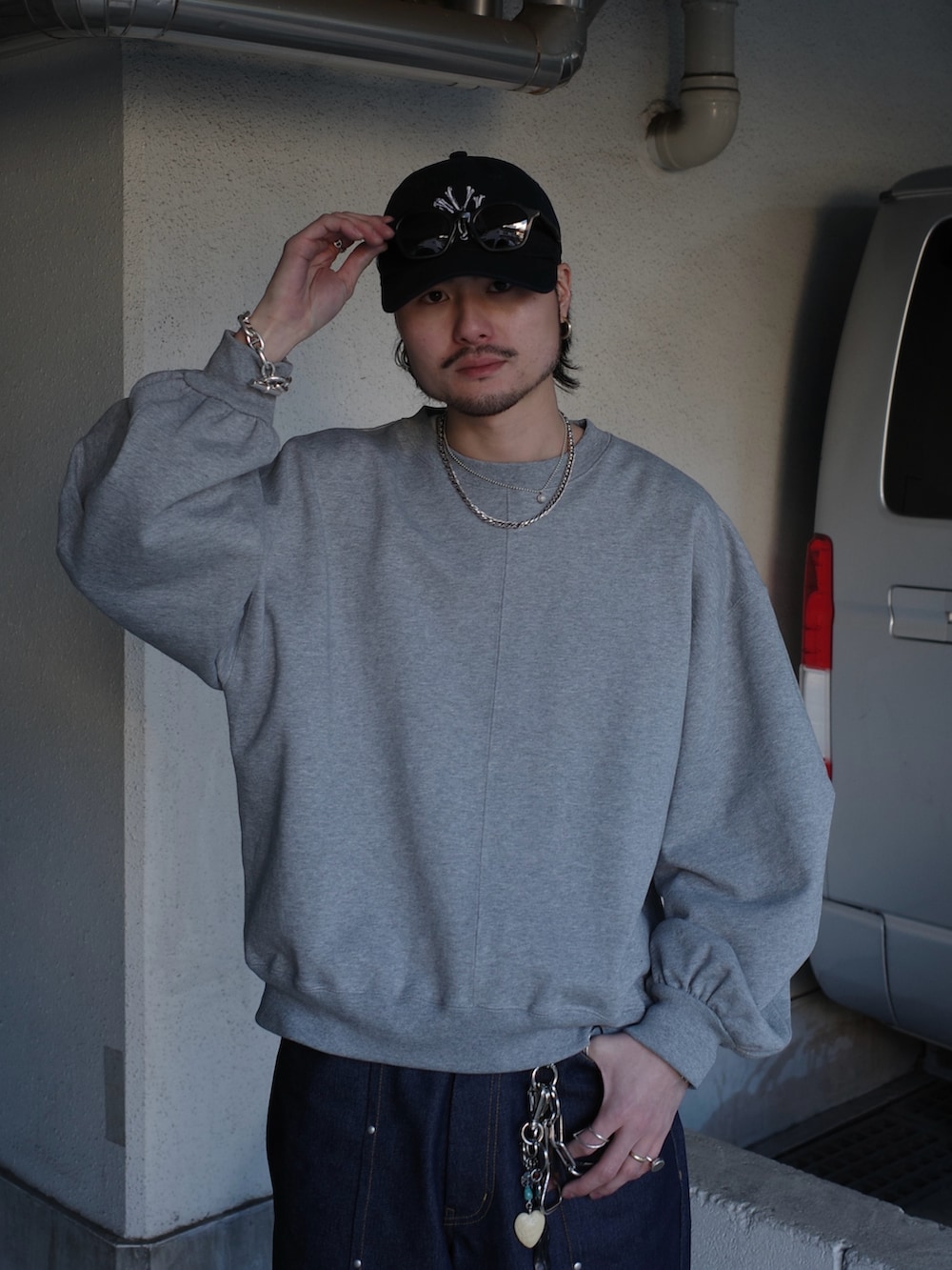 グレー系のスウェット、ブルー系のデニムパンツを着用したメンズの春コーディネートの5枚目の写真