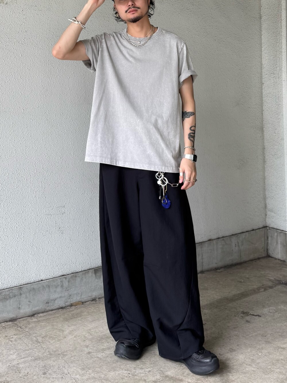 グレー系のTシャツ/カットソー、ブラック系のスラックスを着用したメンズの夏コーディネートの2枚目の写真
