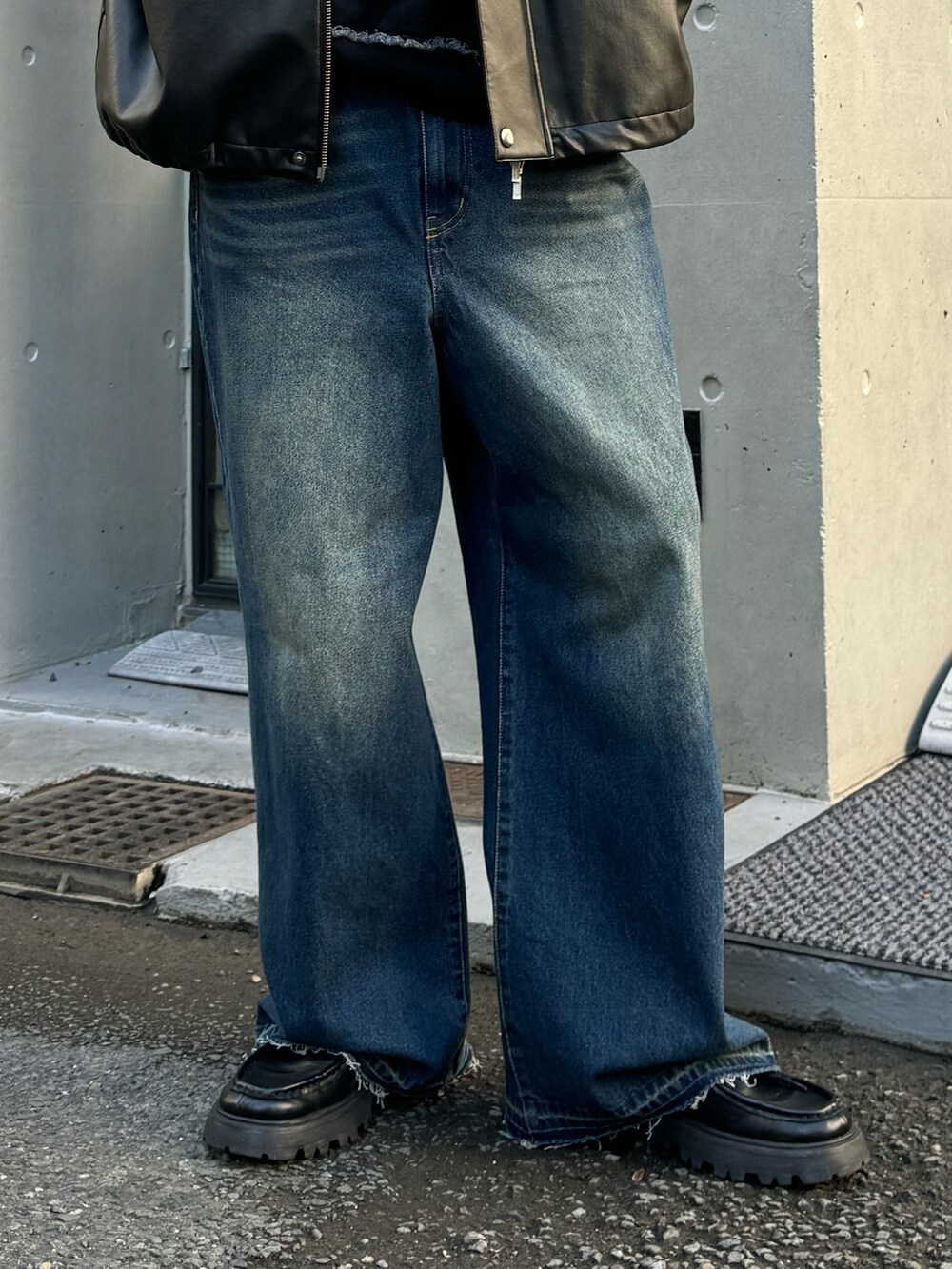 ブラック系のブルゾン、ブルー系のデニムパンツ、ブラック系のブーツを着用したメンズの冬コーディネートの5枚目の写真